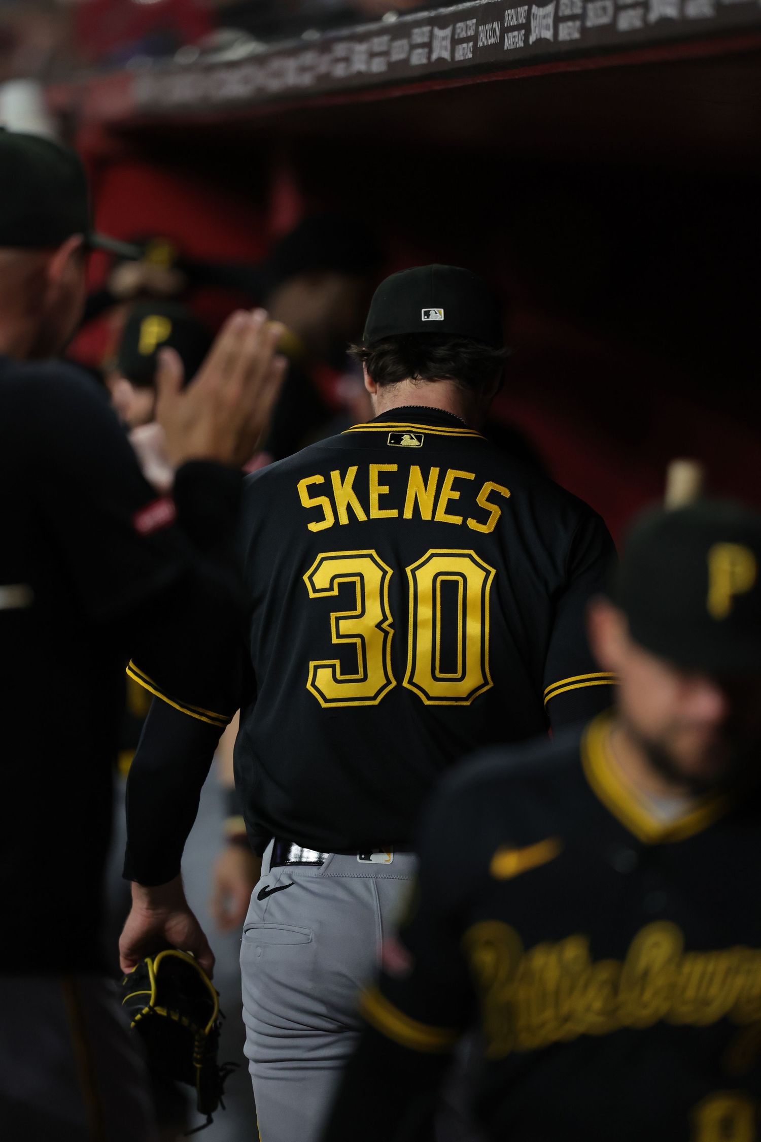 Pittsburgh Pirates player Skenes #30 walks through the dugout in black and gold uniform.