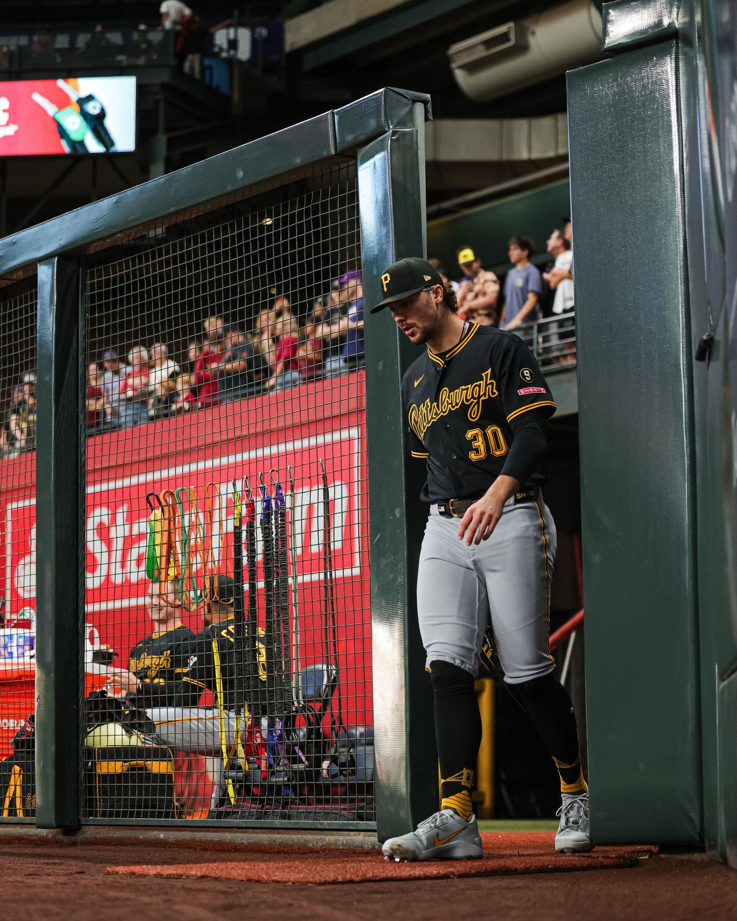 Pittsburgh Pirates player #30 stands in the dugout entrance smiling during an MLB game.