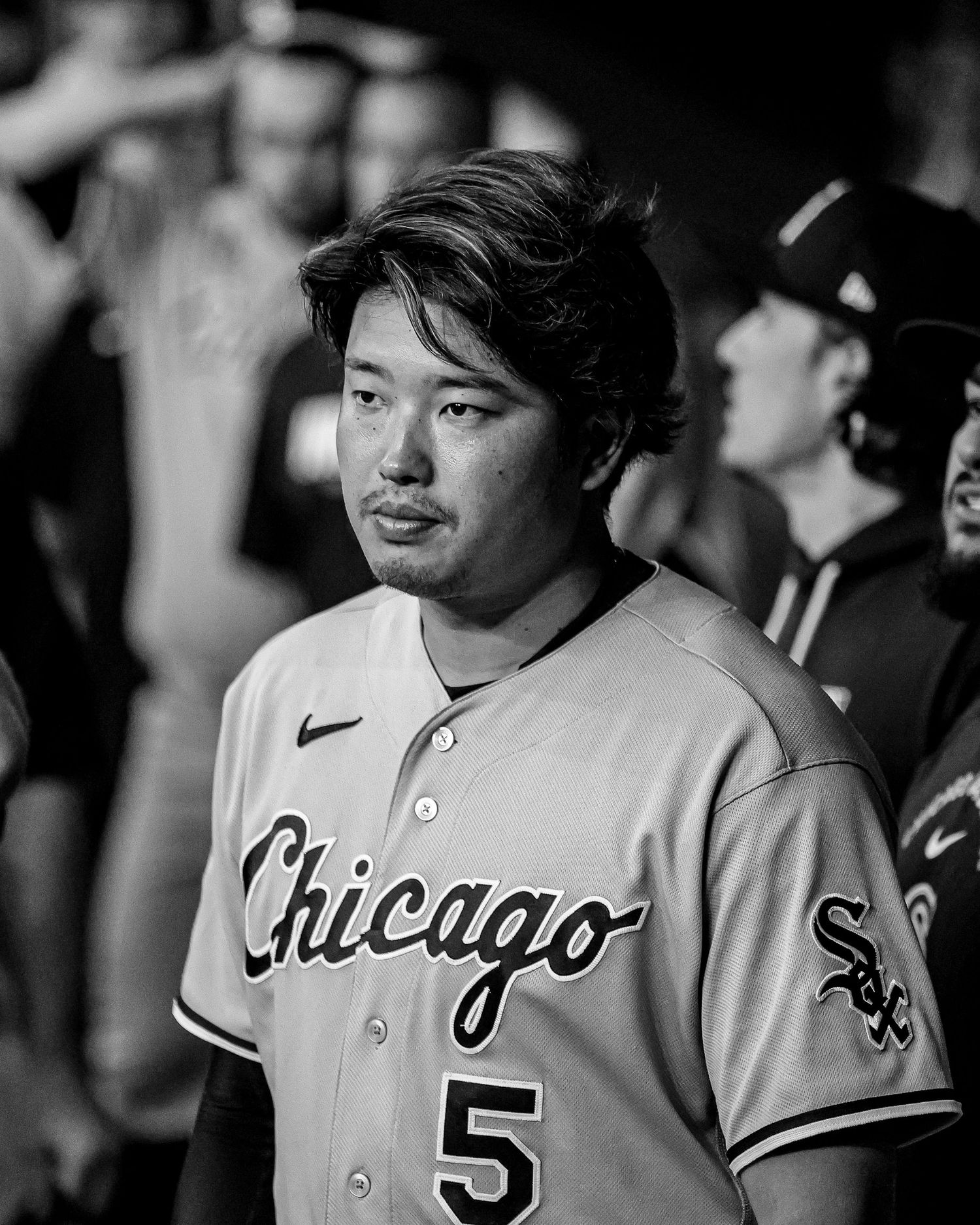 Chicago White Sox player #5 stands in the dugout in black and white photo.