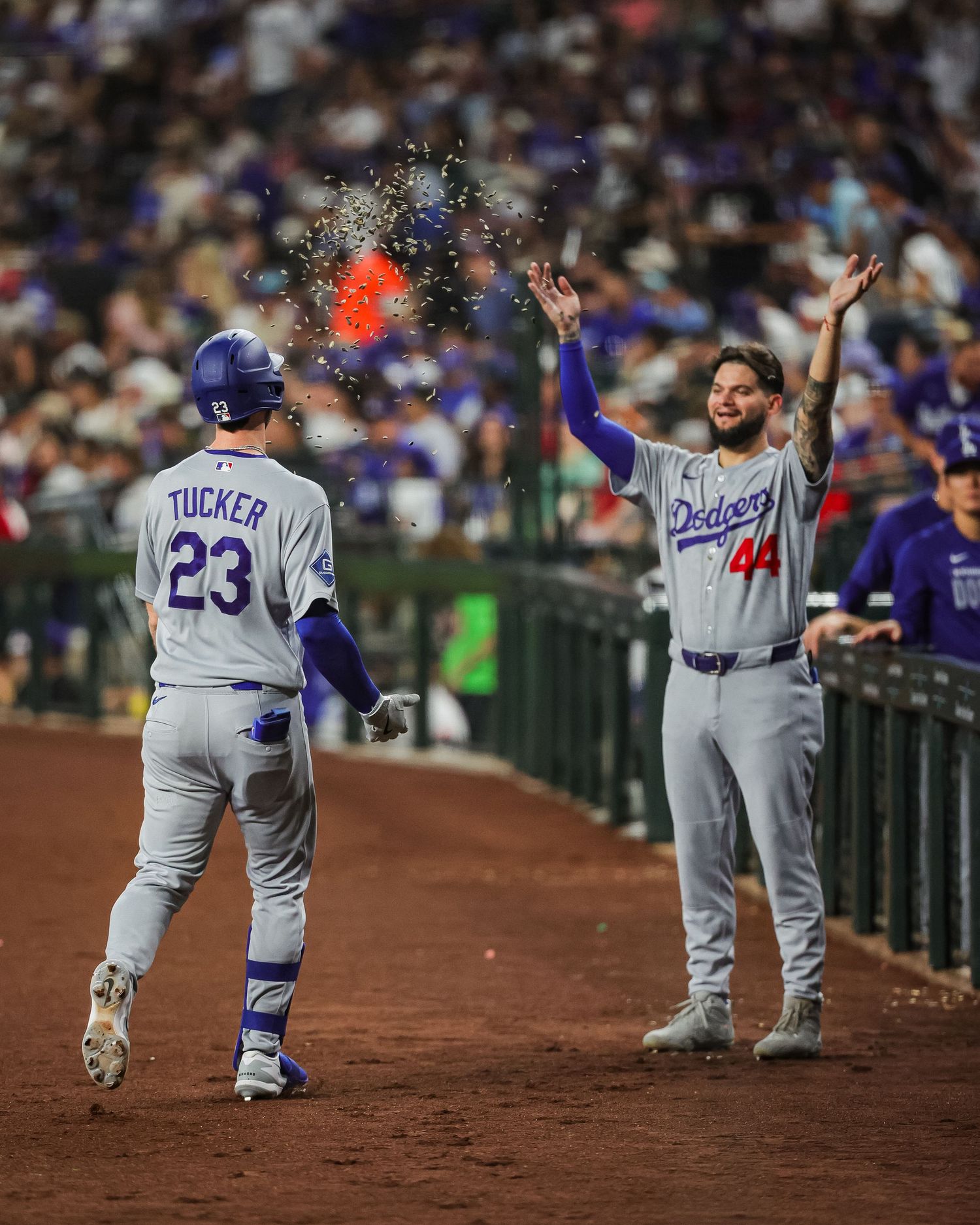 Dodgers players Tucker #23 and #44 celebrate near dugout during MLB game.
