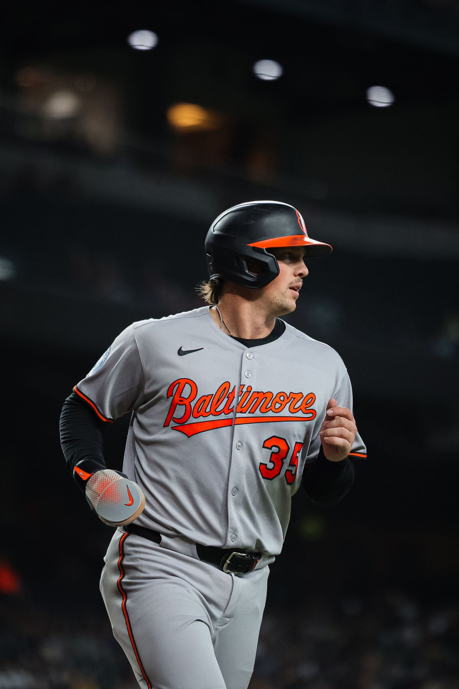 Baltimore Orioles player #35 runs the bases in away gray uniform during MLB game.