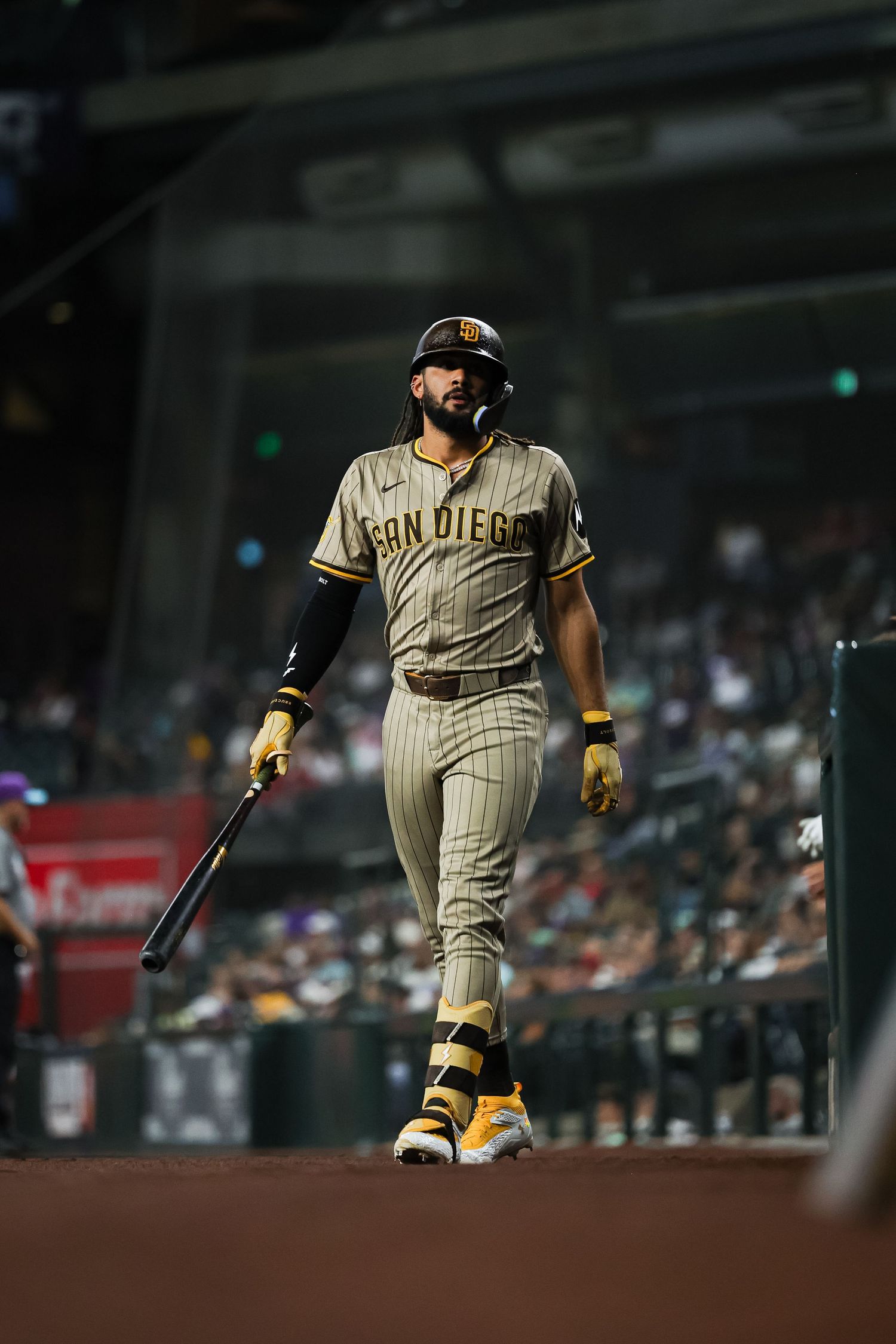 San Diego Padres batter walking to plate in pinstripe uniform during MLB game at Chase Field.