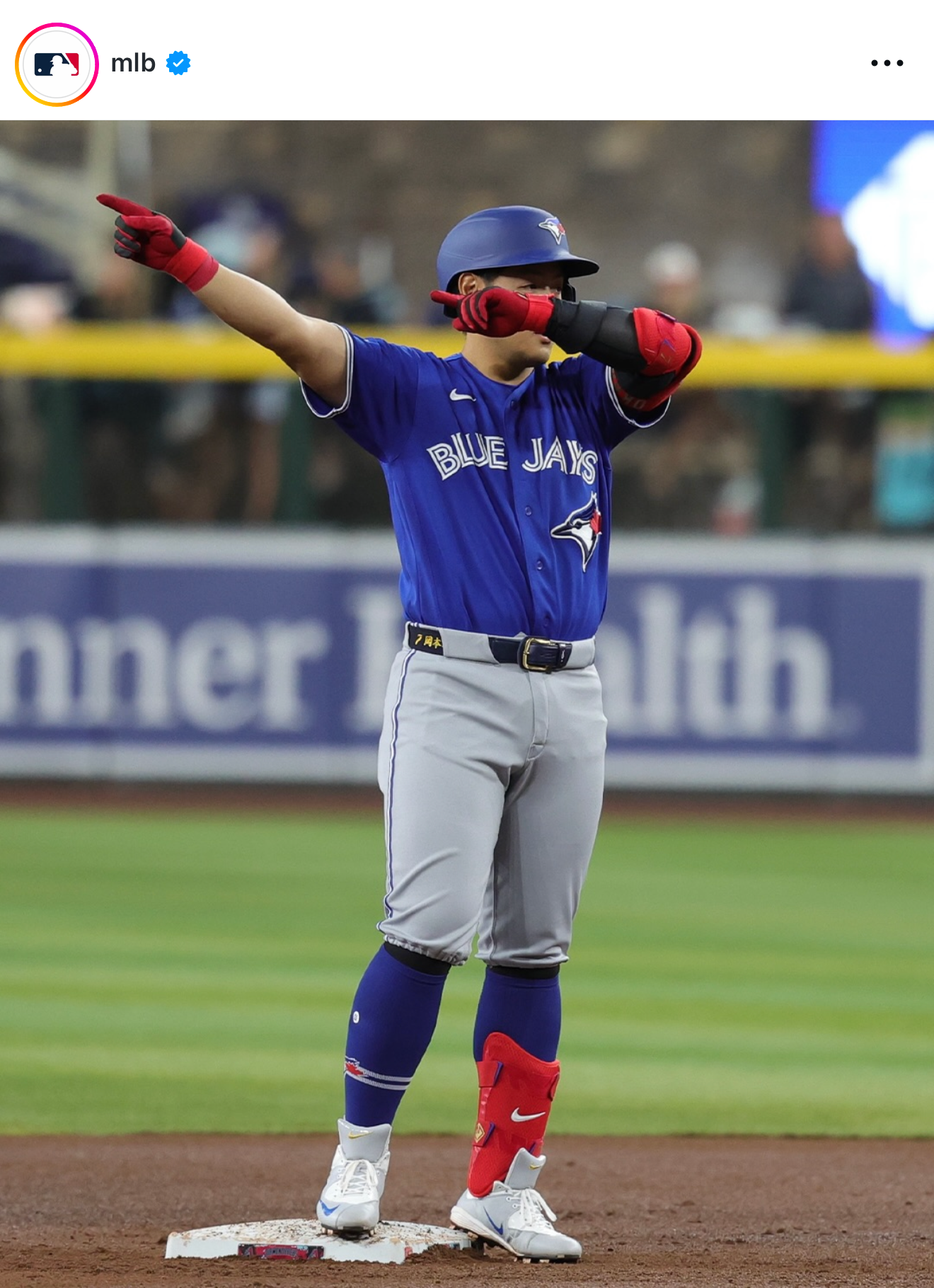 Toronto Blue Jays MLB player stands on second base pointing upward during a spring training game.