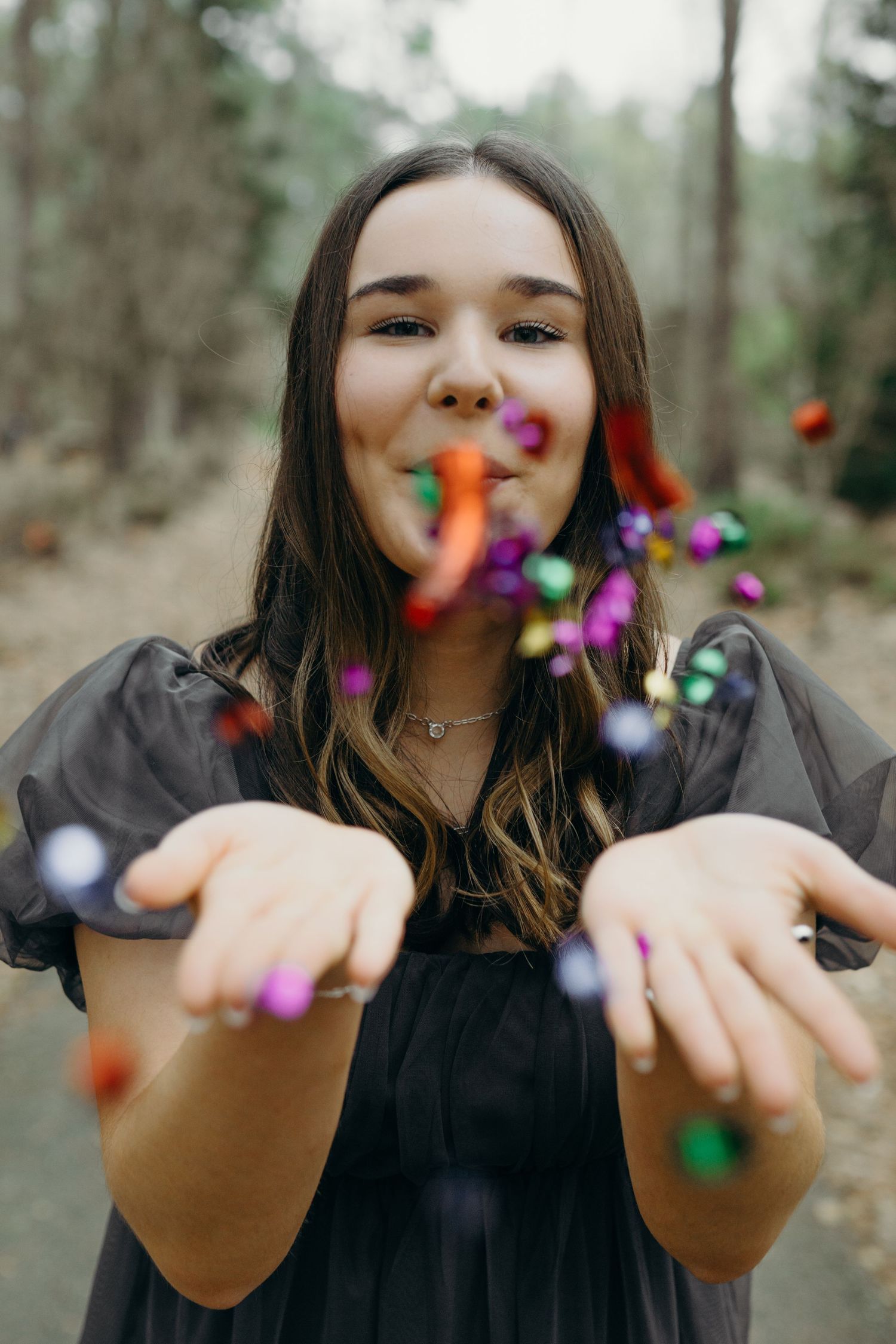 Senior graduate throwing flowers for her senior session in Eugene, OR