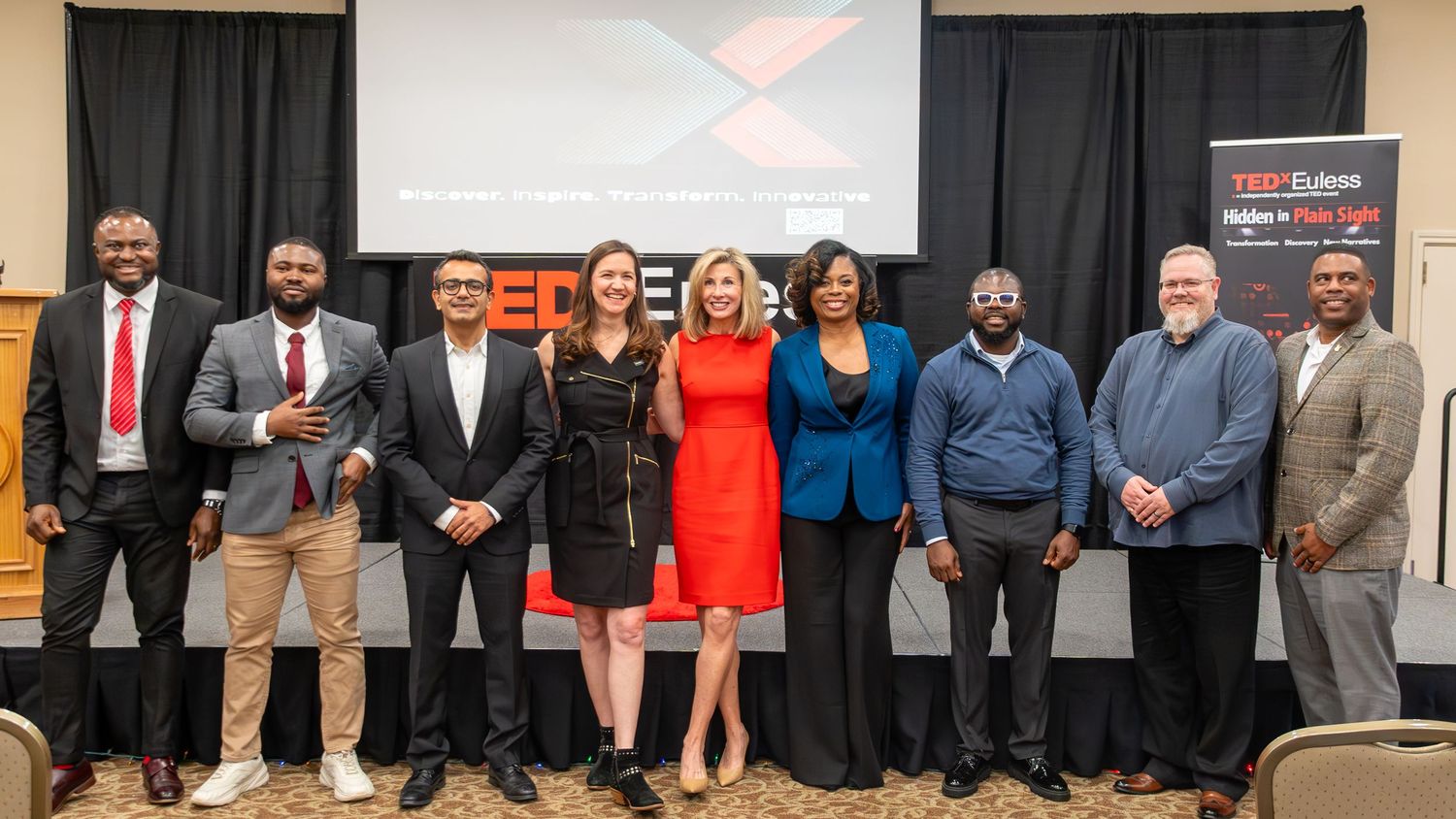 Group of TEDx speakers and organizers posing together on stage
