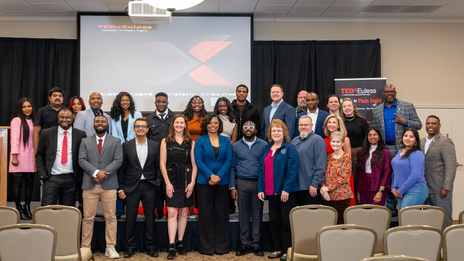 Large group of TEDx event attendees posing together indoors