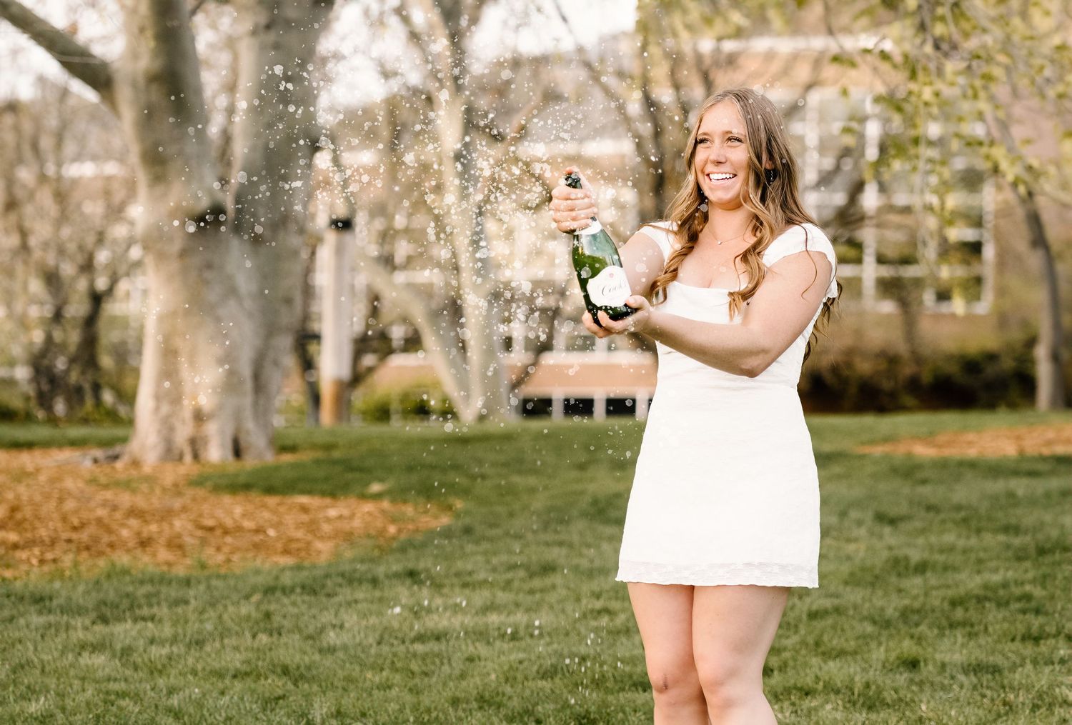 A graduate popping some champagne