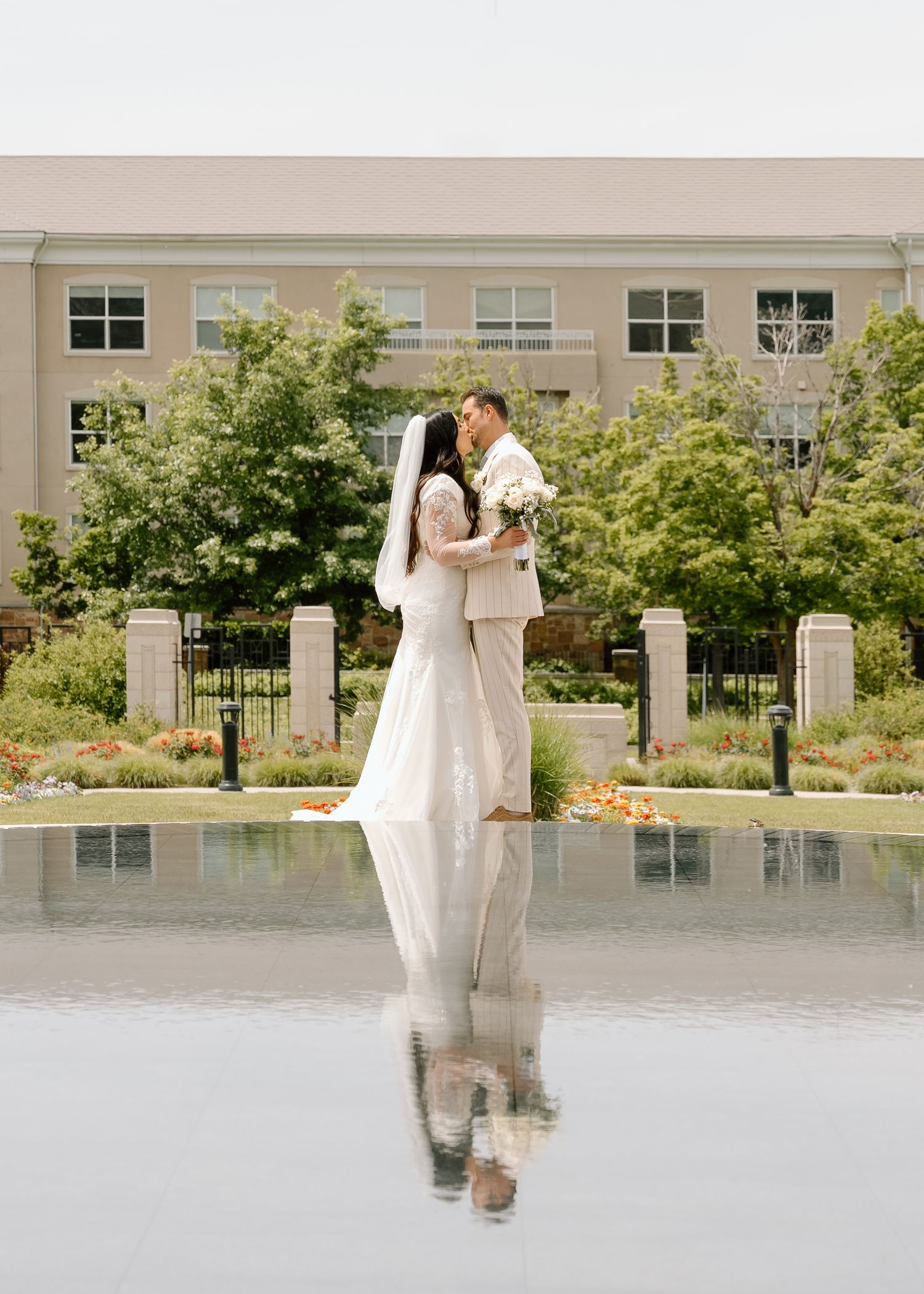 A bride and groom reflected in the fountain at the Utah, Ogden LDS temple