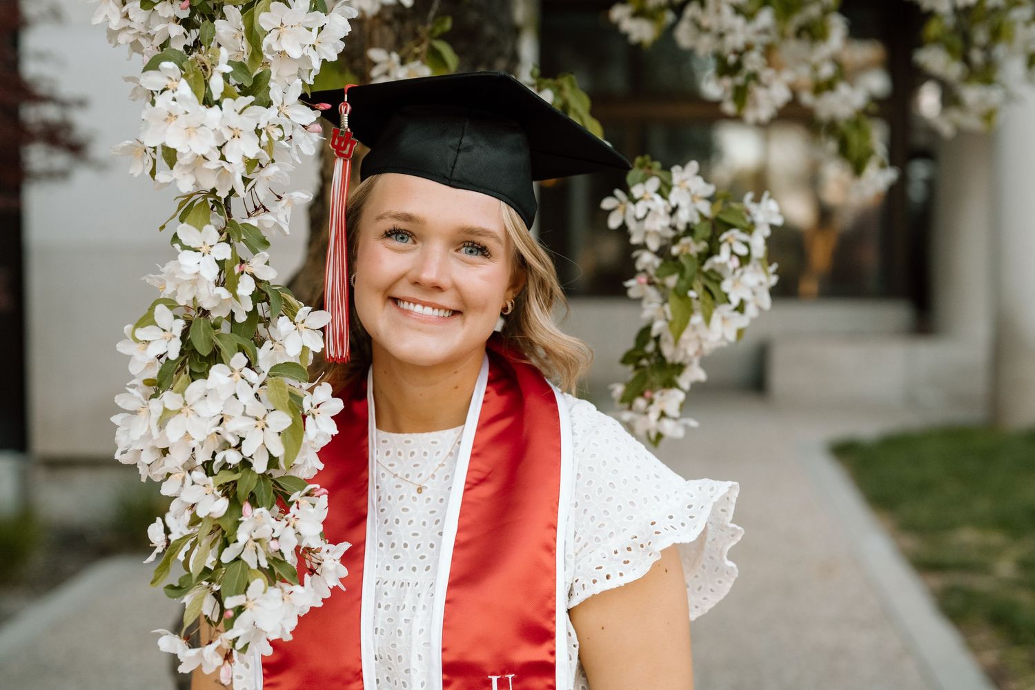 A University of Utah graduate in stol and cap with white cherry blossoms