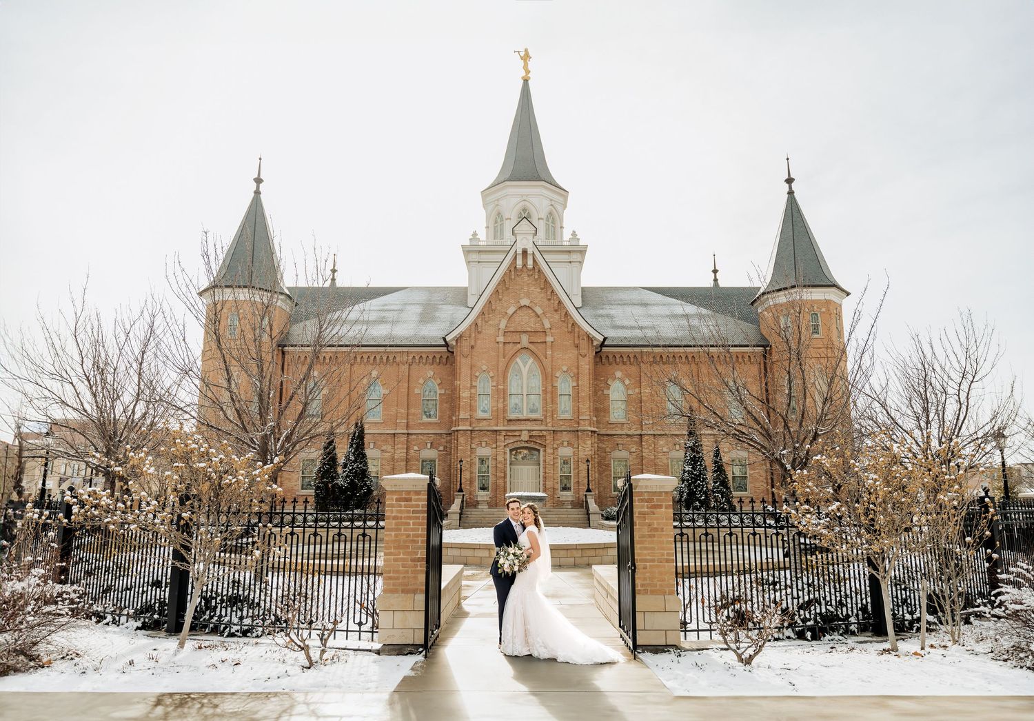 Bride and groom in front of the Provo City Center LDS Temple with snow on the ground