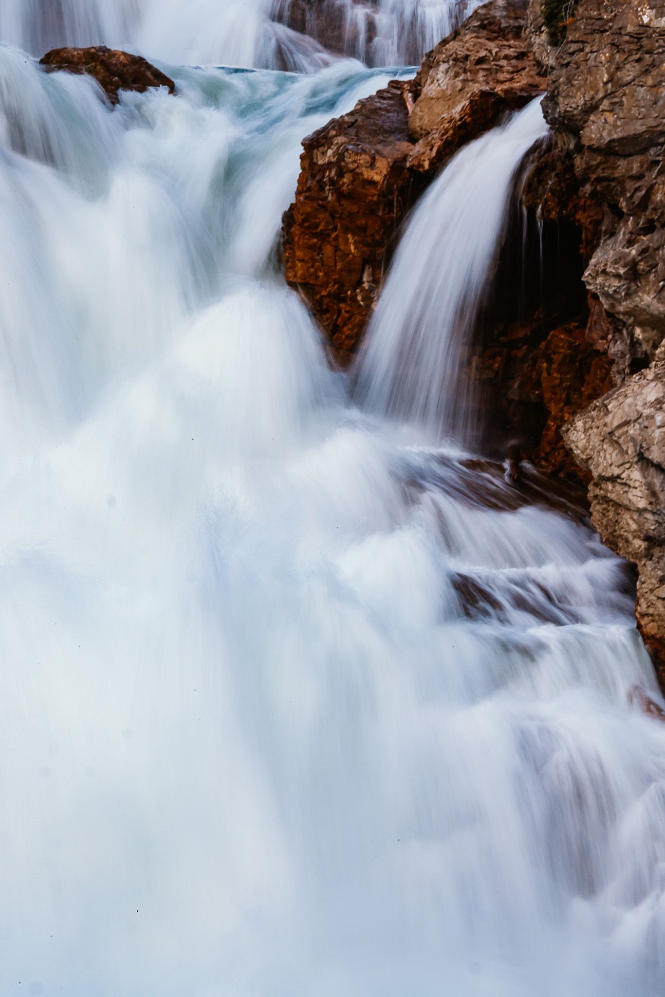 Powerful waterfall cascading over rocky cliffs with silky smooth water motion.