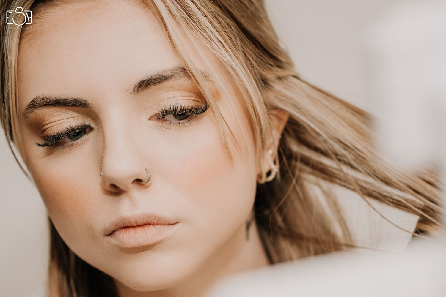 Close-up beauty portrait of woman with natural makeup and flowing blonde hair.