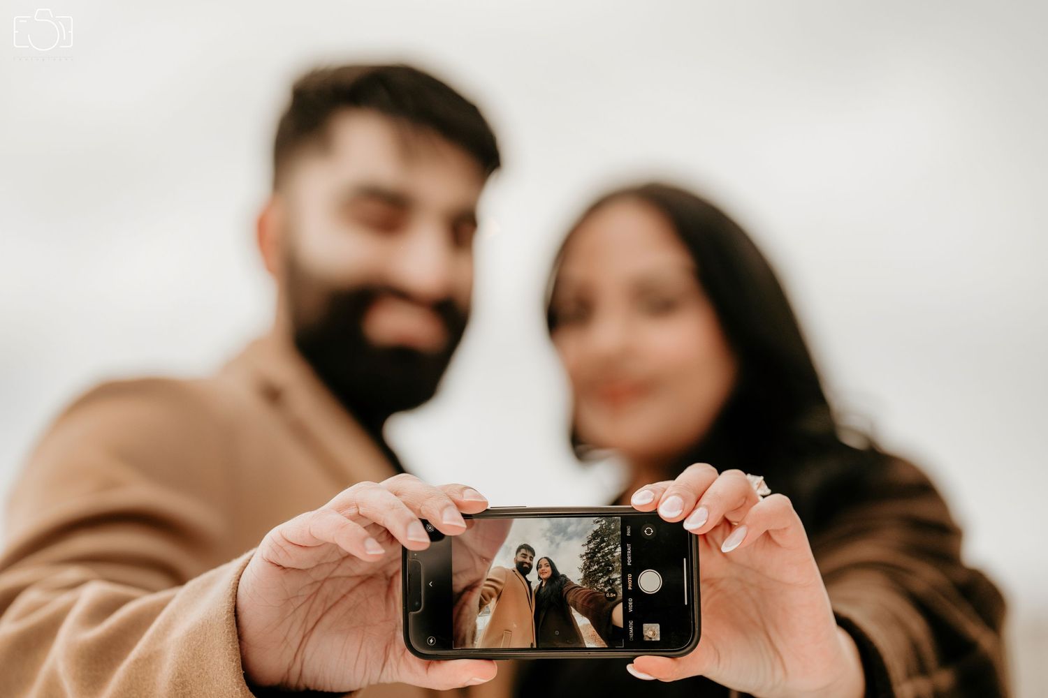 Couple taking a selfie together while showcasing their loving connection.
