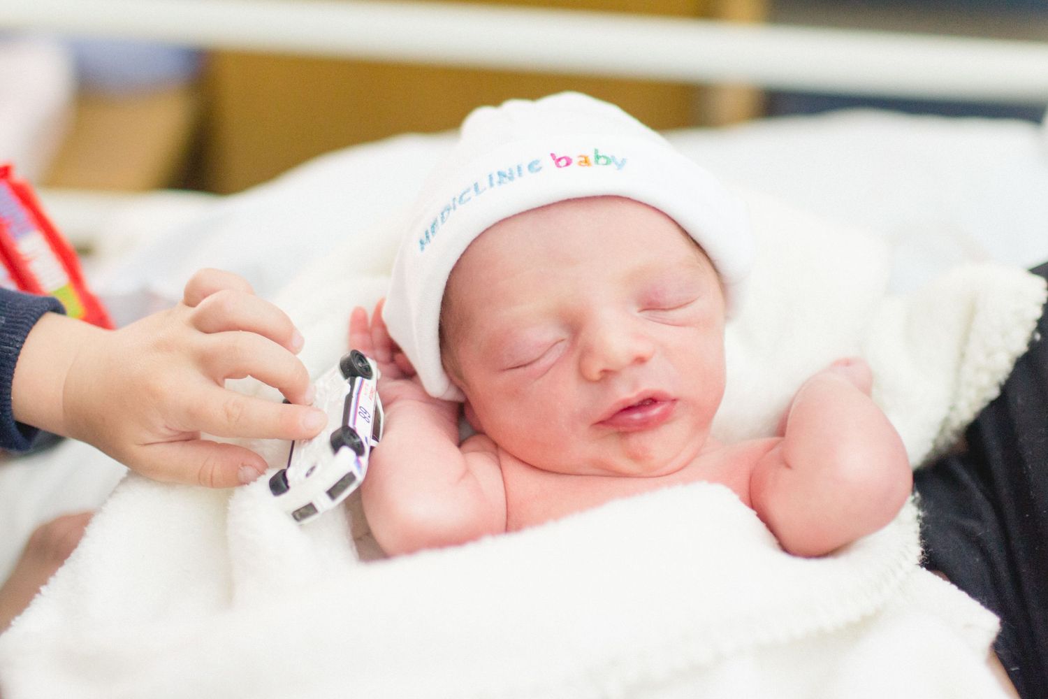 Brother giving car to his new baby brother, already sharing. Fresh Newborn . Birth Photography