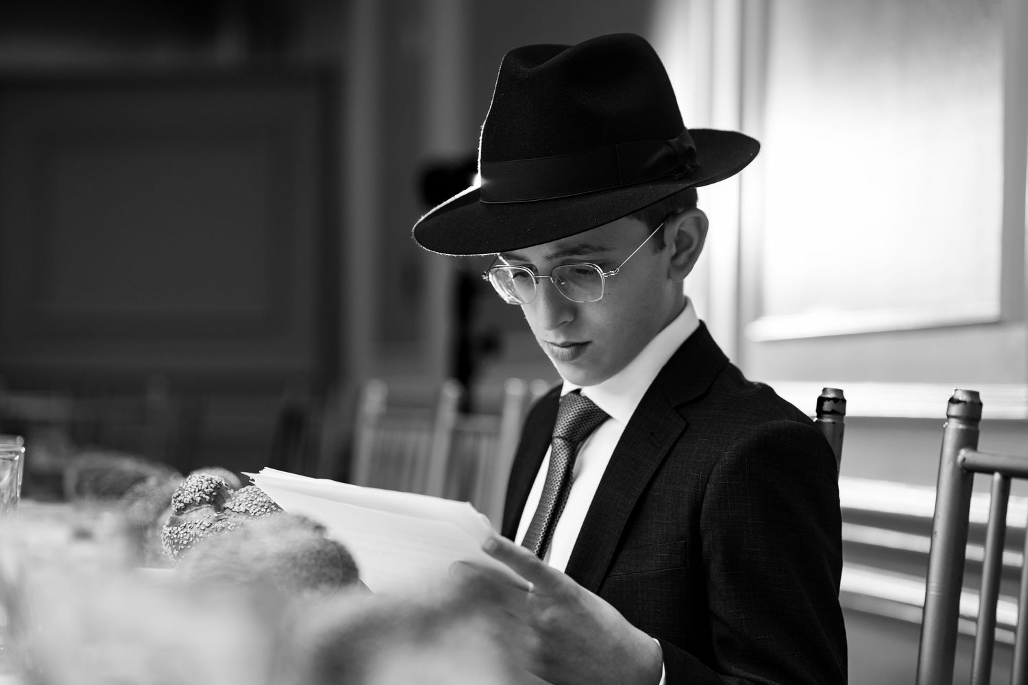 Black and white photo of people wearing traditional black hats in discussion.