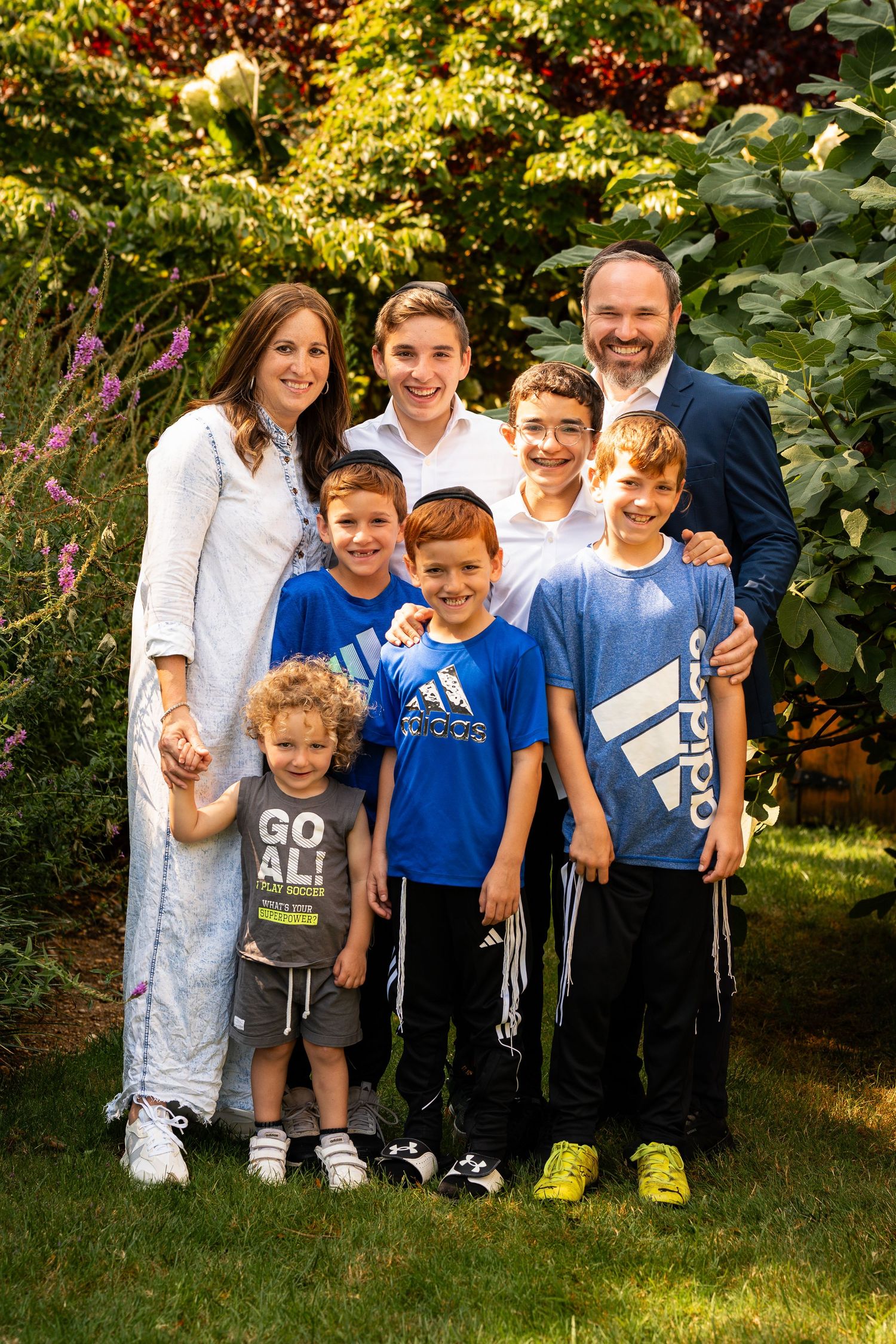 A group portrait outdoors with colorful autumn foliage in the background.