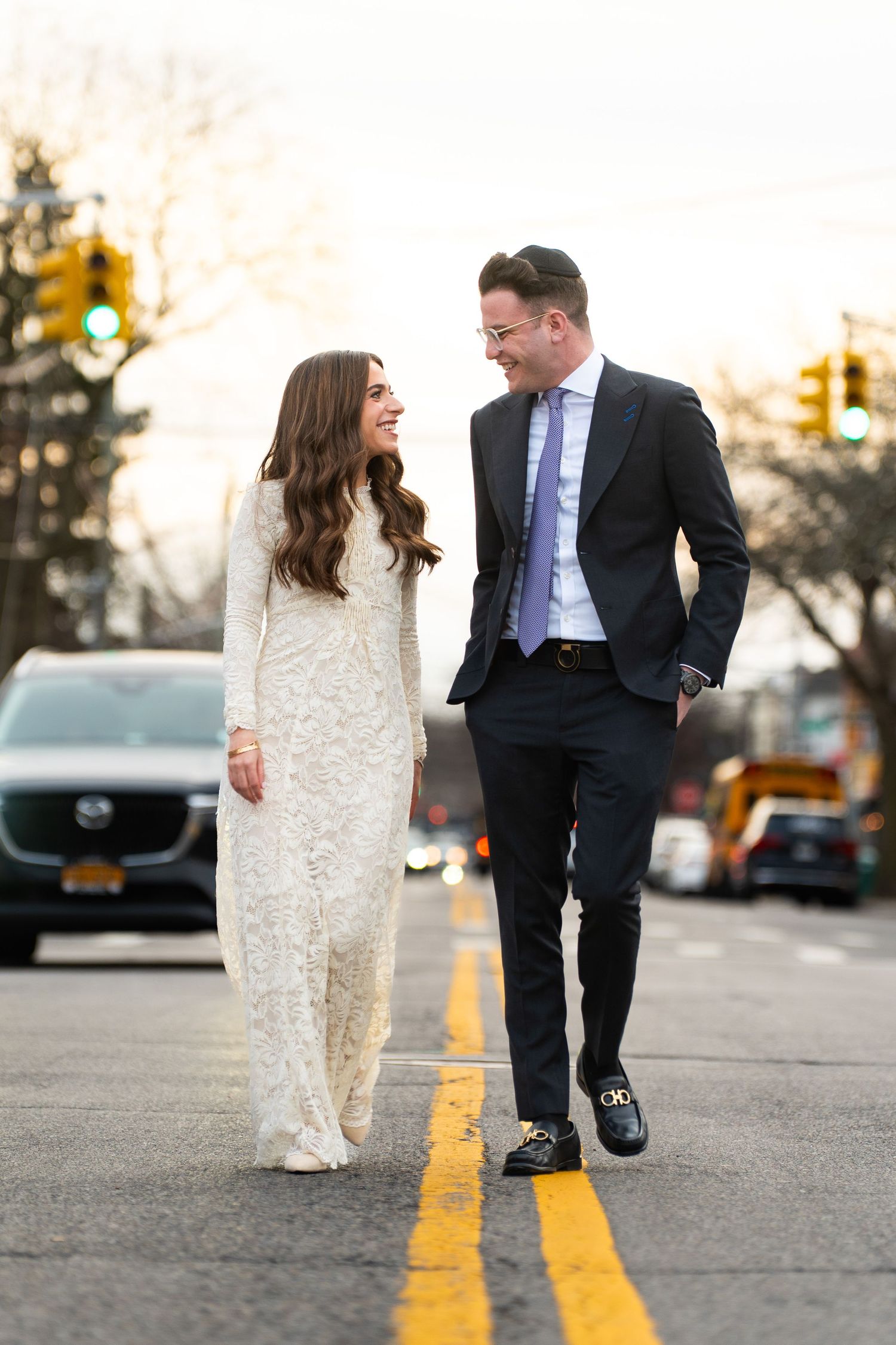 A joyful moment shared while walking down a city street at sunset.