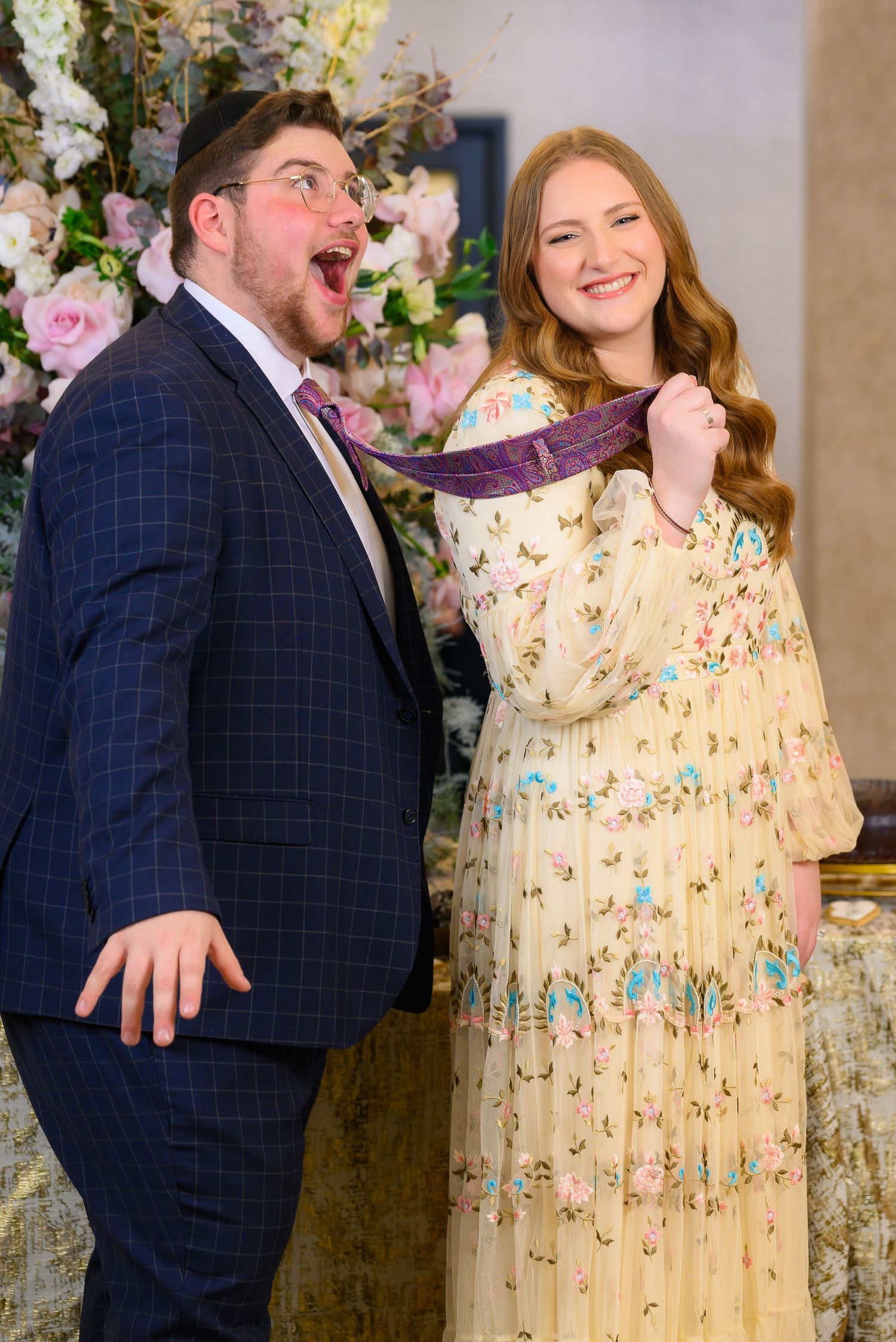 Indoor portrait session featuring floral decor and elegant yellow floral dress.