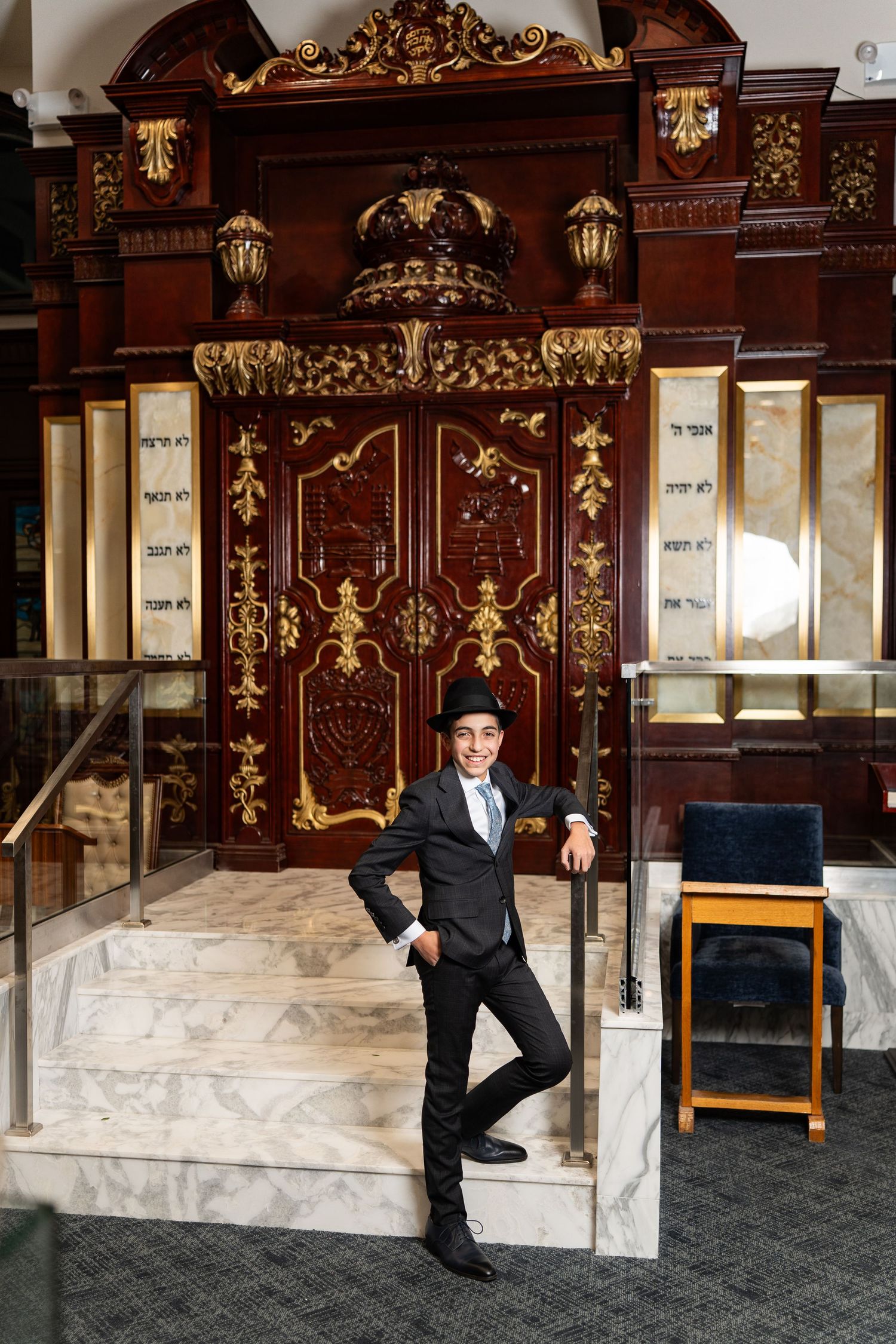 Elegant ornate wooden doorway with intricate gold details and lanterns in a luxurious interior setting.