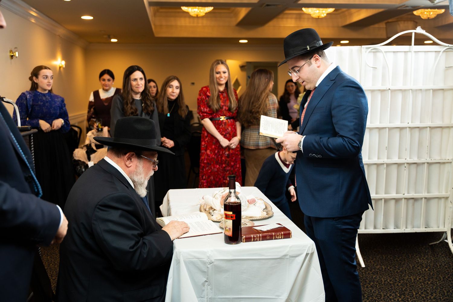 People signing papers and documents at tables during what appears to be a formal business or legal event.