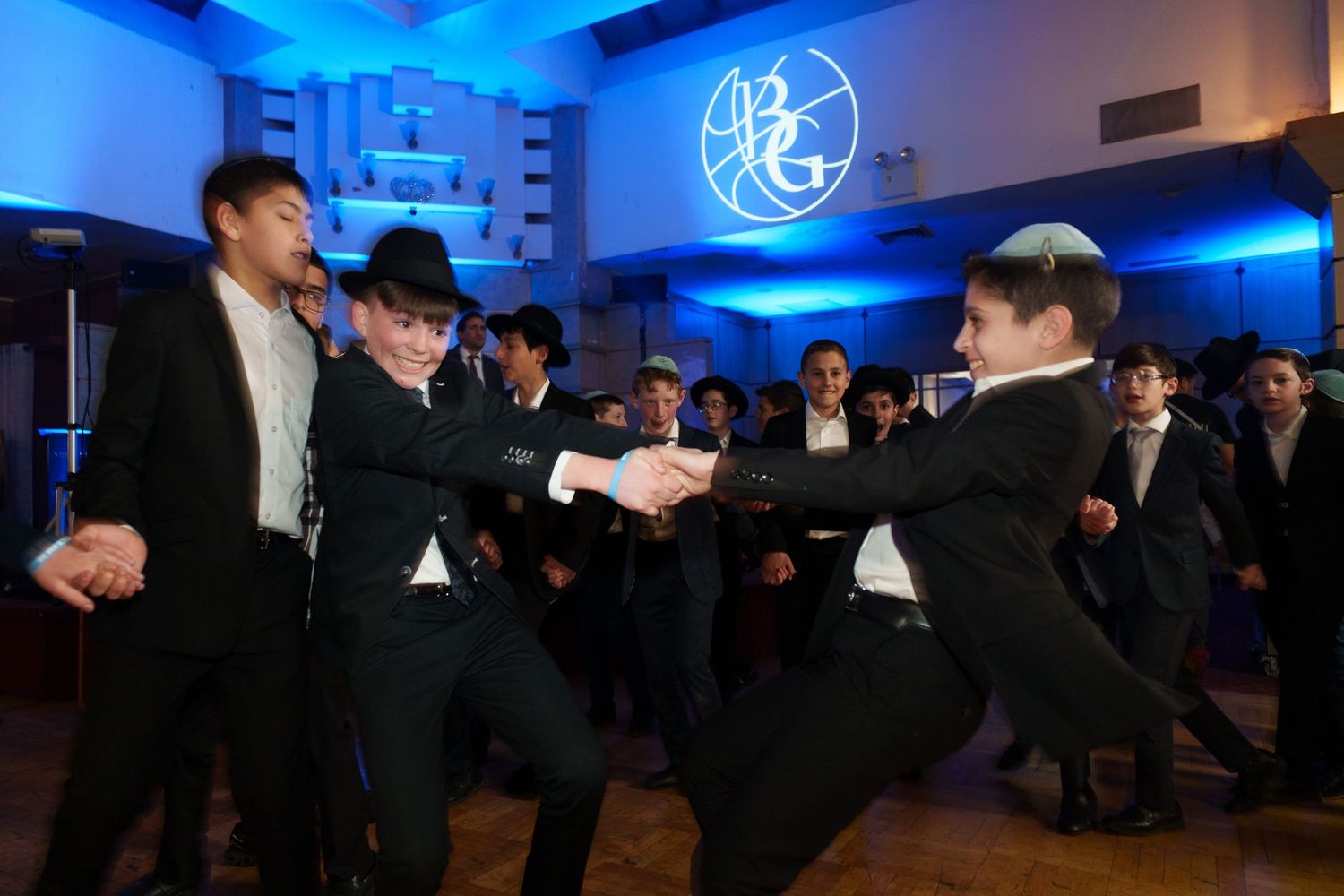 Formal celebration in room with blue lighting and traditional attire.