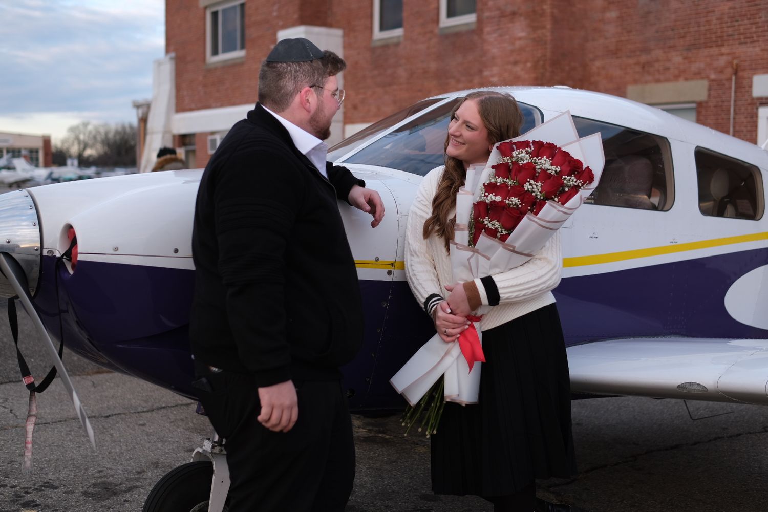 Flying lesson near a small aircraft with people examining flight instruments and controls.