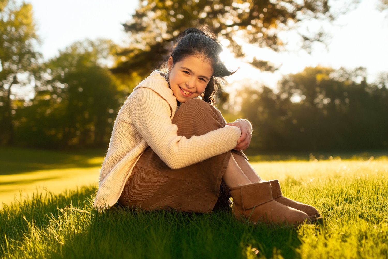 People relaxing together on grassy hill during sunset in peaceful outdoor scene.