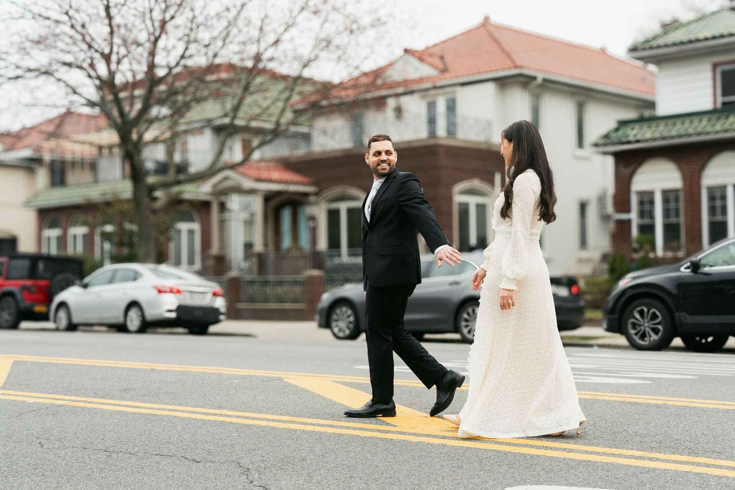 Couple dancing and posing together on a street during their wedding day celebration.