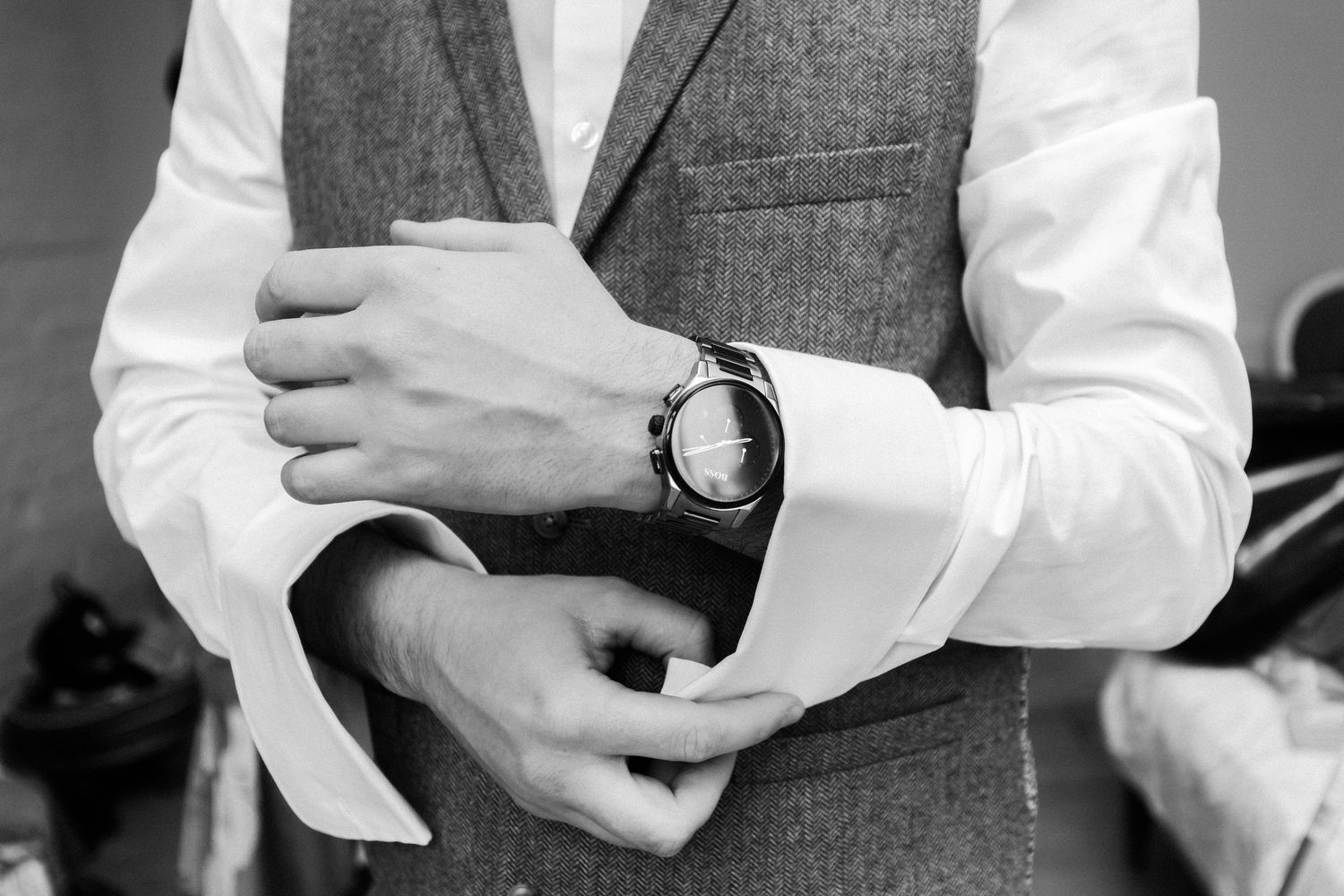 A series of black and white close-up photos showing hands adjusting dress shirt cuffs and vest details.