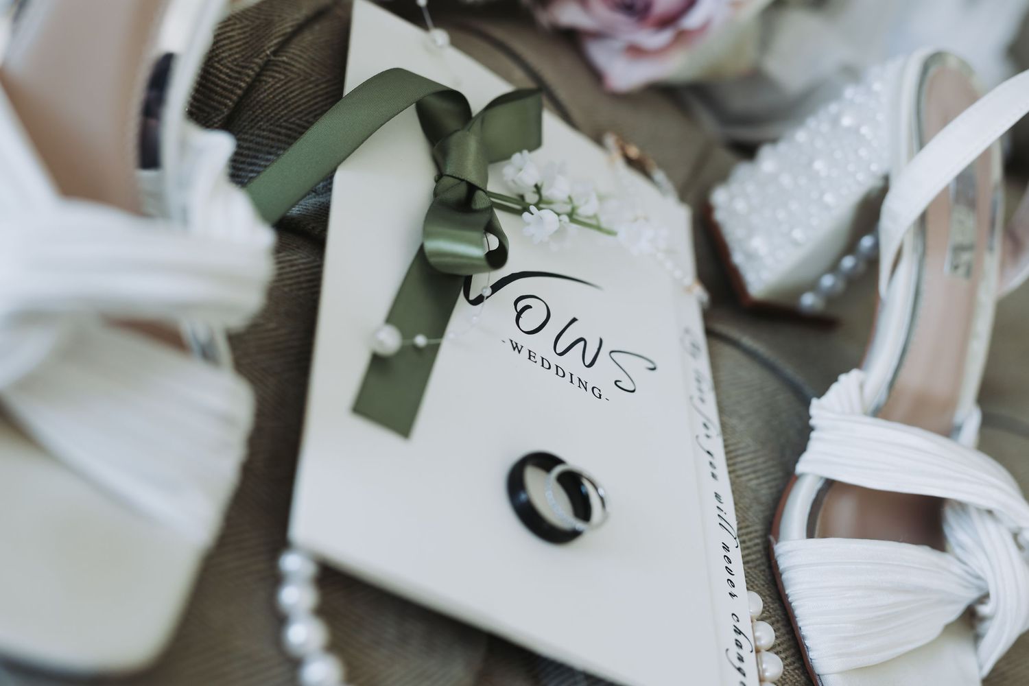 Assorted white gift boxes with olive green ribbons and bows arranged in an elegant display.