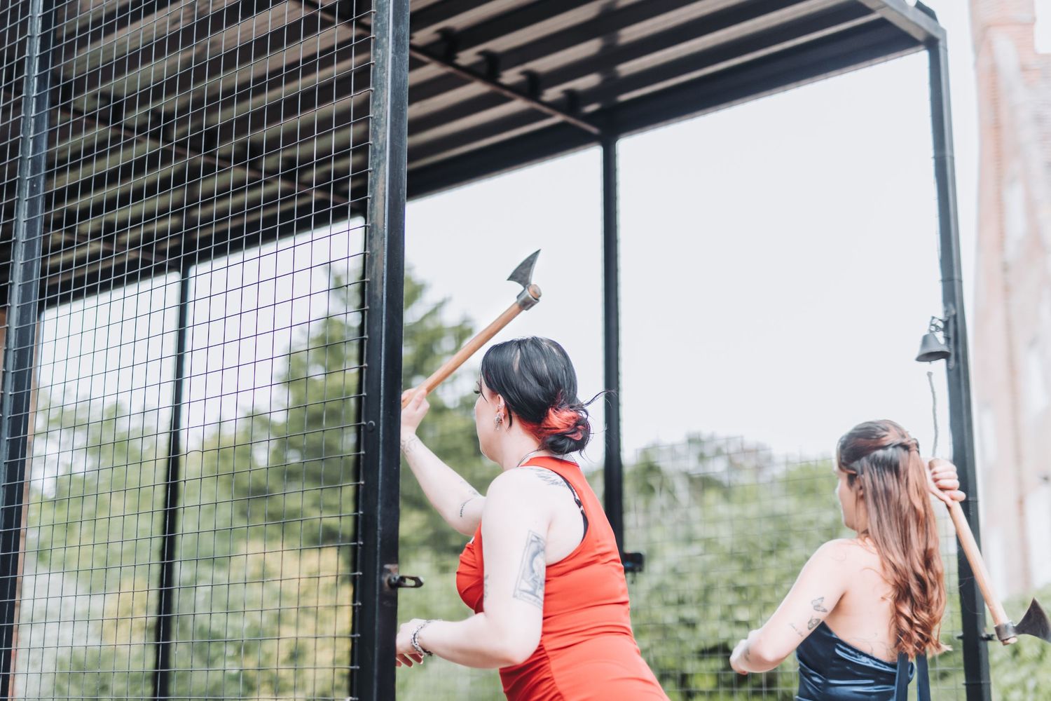 Group of people playing a competitive game in an indoor sports facility with protective netting.