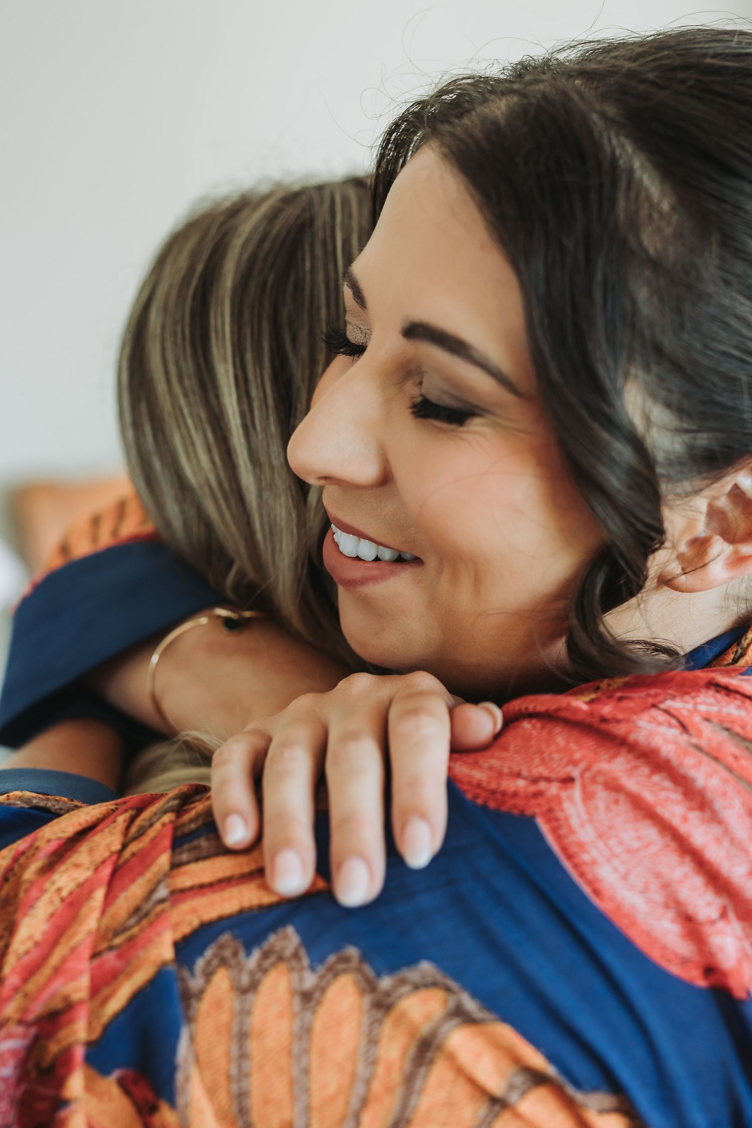 A tender moment captured in a series of photos showing an emotional embrace between two people wearing coral and navy.