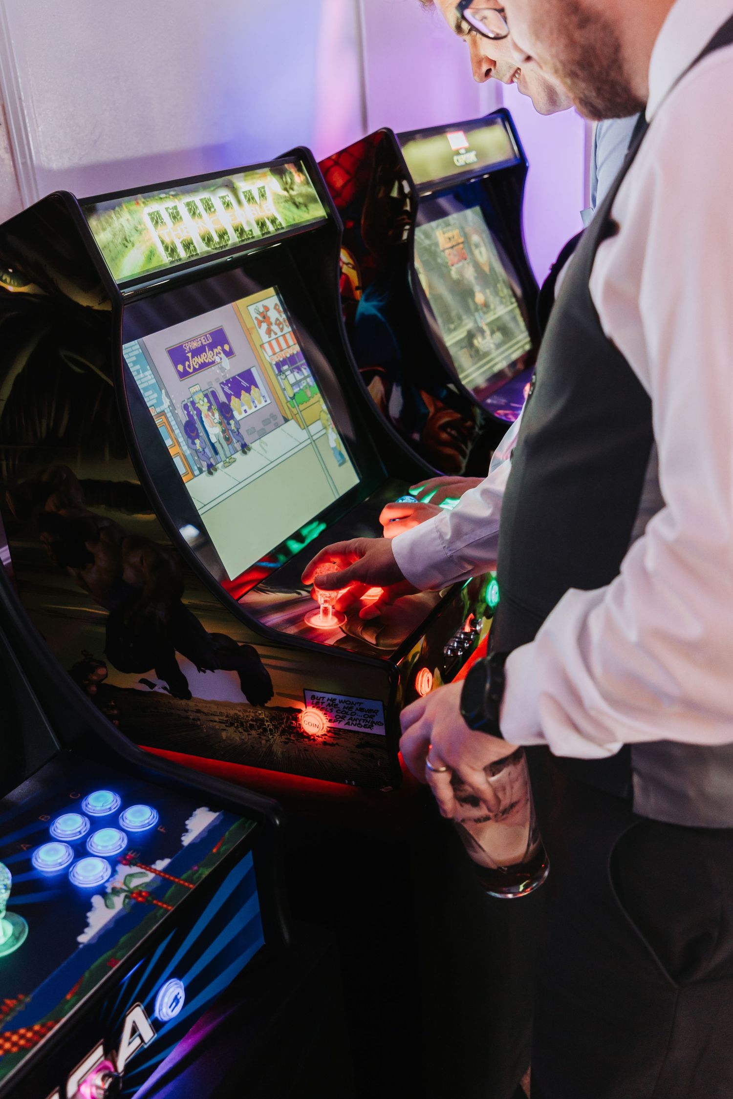 Arcade gaming setup showing multiple screens with blue and red illuminated control panels for competitive play.
