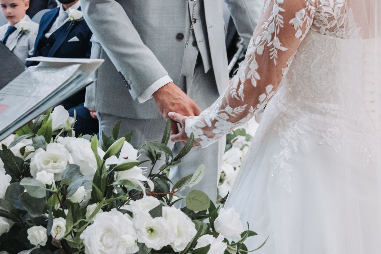 A close-up view of elegant white wedding bouquets with roses and greenery arranged for a formal ceremony.