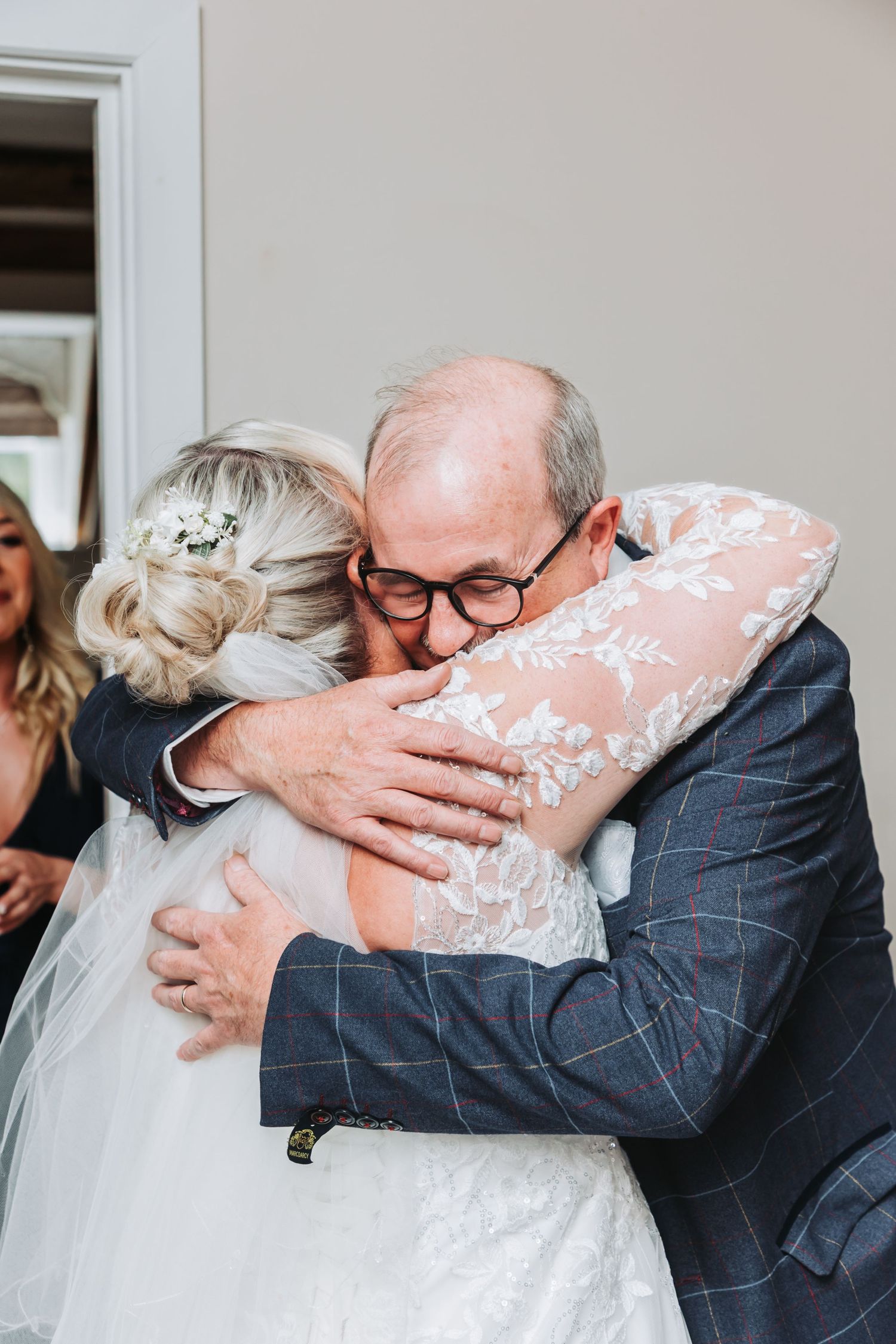 A sequence of emotional embraces between someone in a dark suit and someone in a wedding dress and veil at a ceremony.