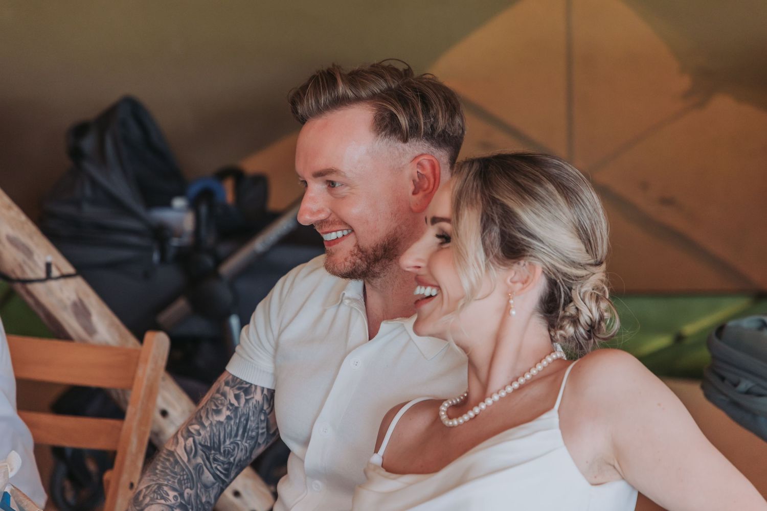 Wedding guests share a candid moment of laughter during a reception celebration.