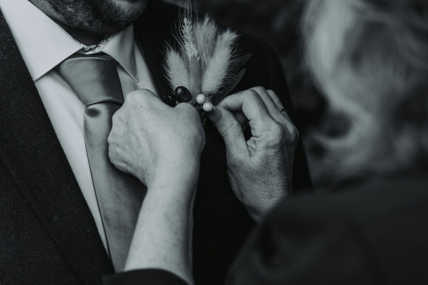 A black and white photo of a couple embracing in an intimate moment during their wedding celebration.