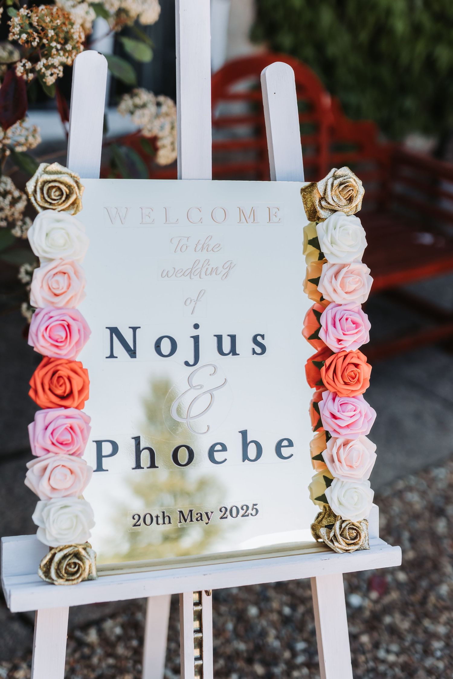 Wedding welcome signs decorated with pink and white roses displayed on white frames for Nojus and Phoebe's celebration.