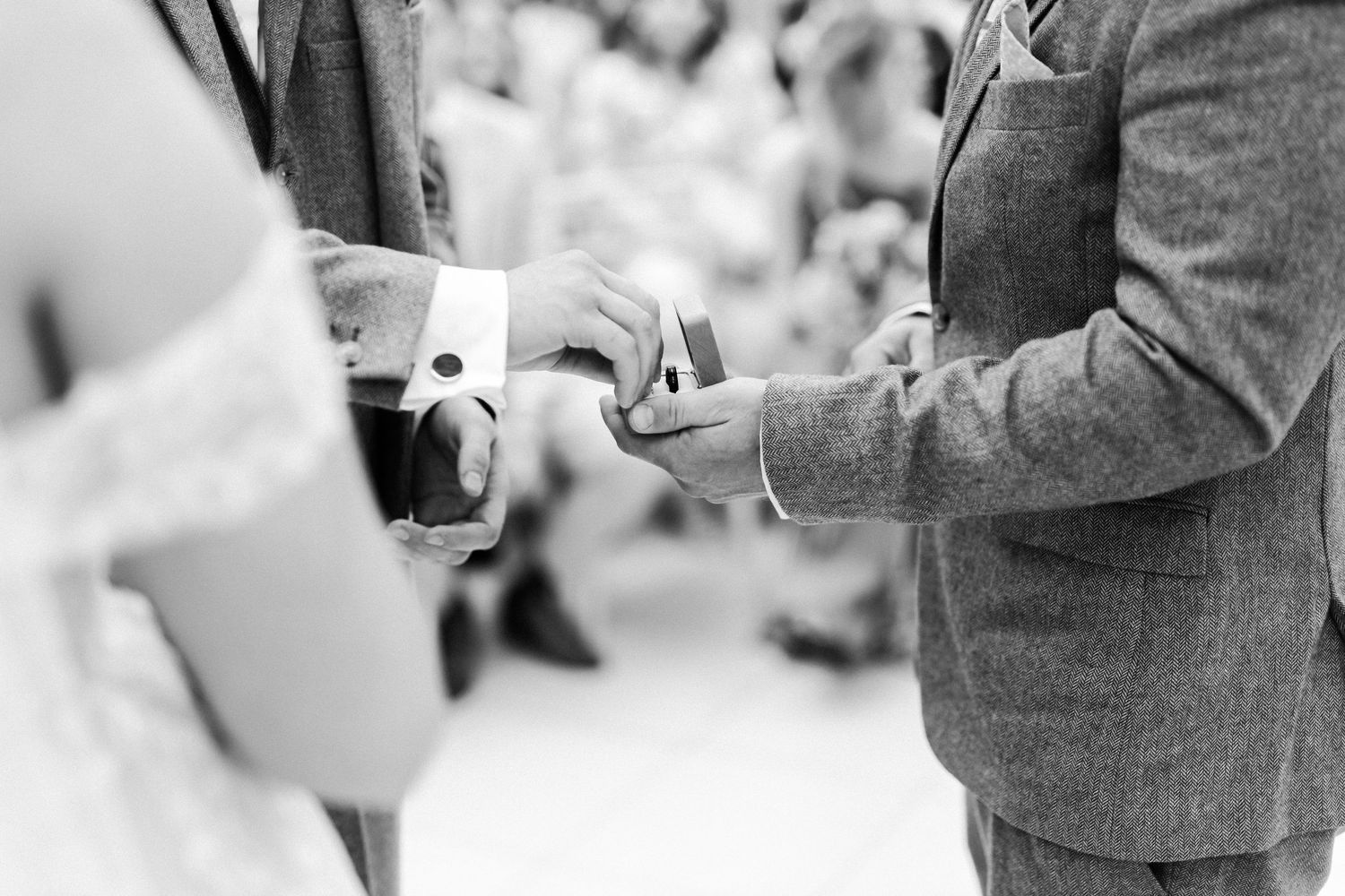 Black and white wedding photo series showing formal attire and interactions during the ceremony.