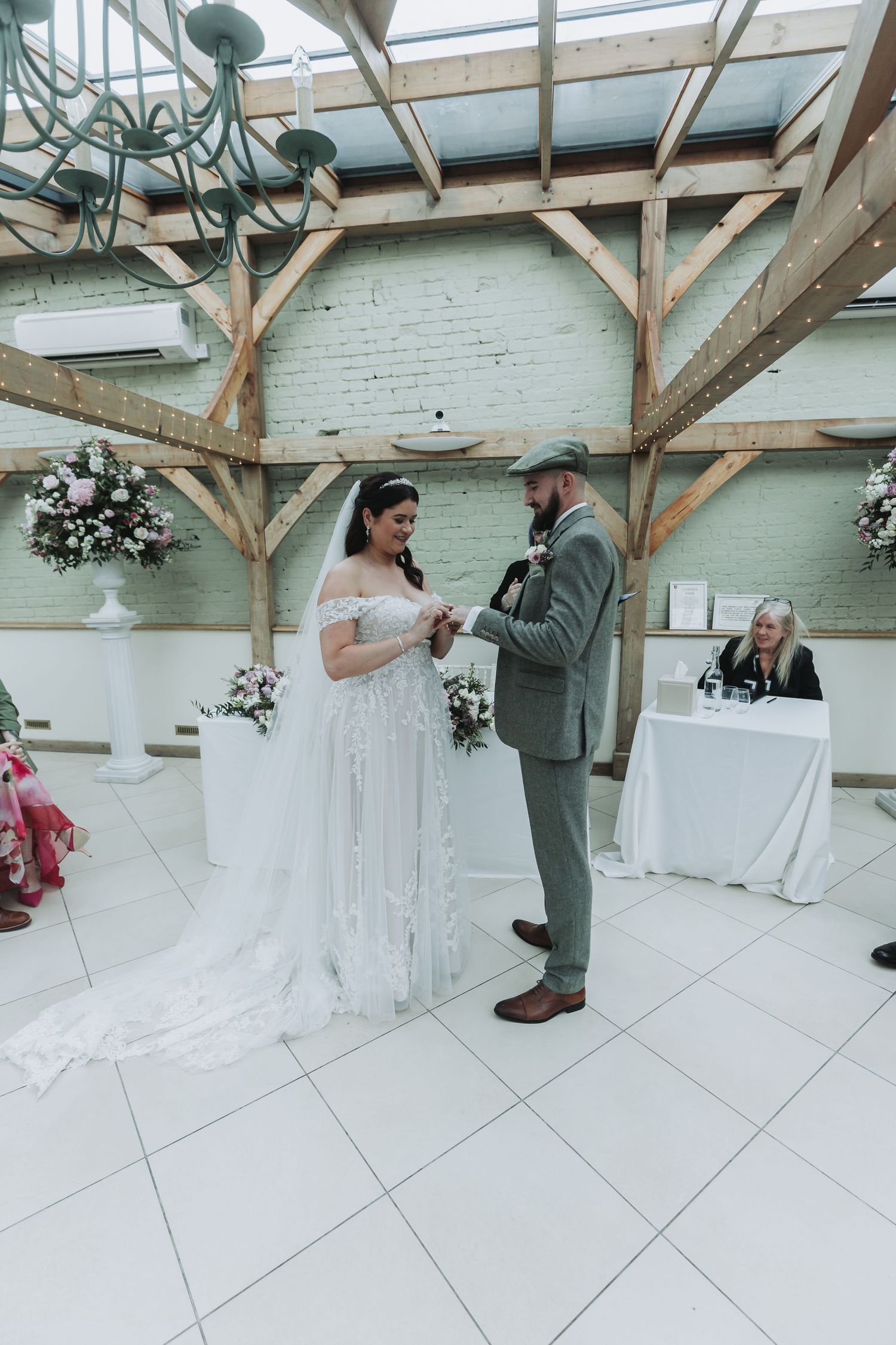 A series of photos showing a first look moment between a bride in white and groom in grey at an indoor venue.