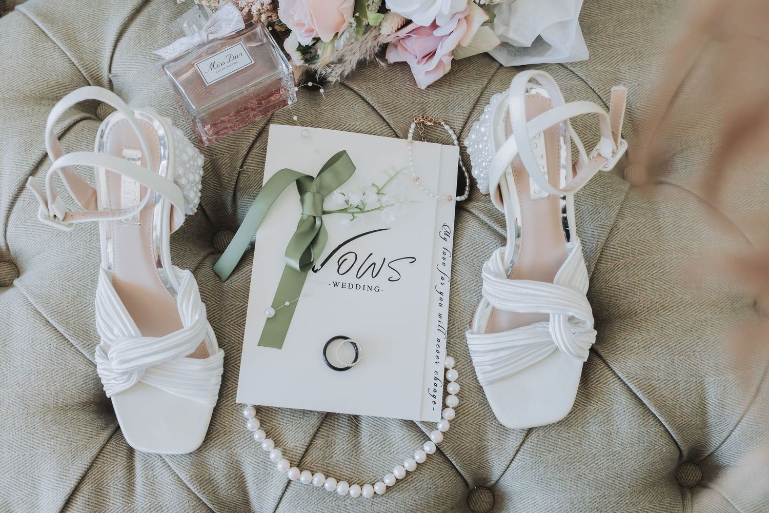 Elegant white wedding shoes and accessories arranged in a row on a neutral background.