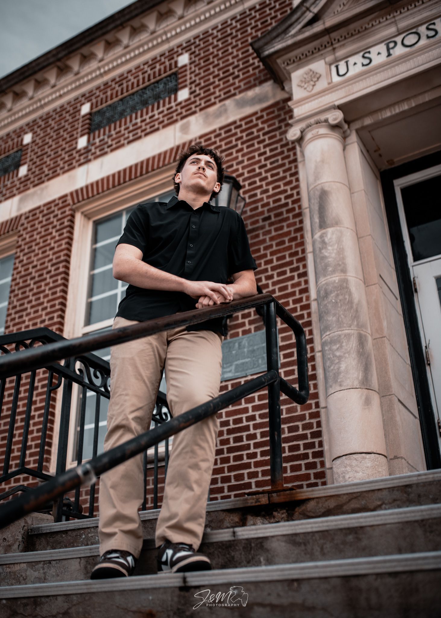 A dramatic low angle shot of someone on the steps of a historic US Post Office building.