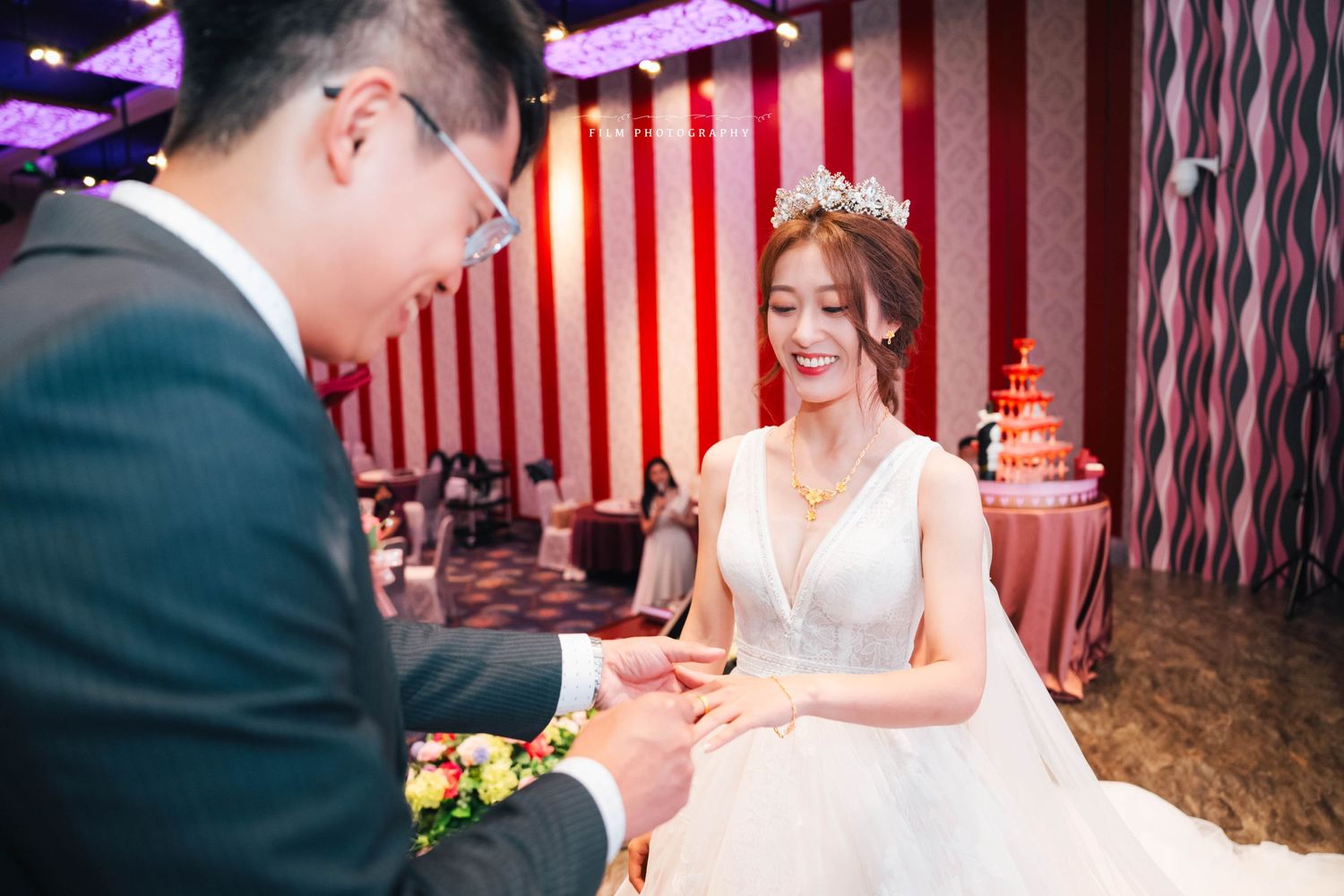 新郎新娘在戶外證婚儀式上交換戒指、擁抱親吻的感動瞬間，紀錄真摯情感的婚禮攝影作品。從文定儀式、迎娶拜別、到午宴晚宴現場賓客互動，每張照片忠實呈現婚禮當天的故事節奏。風格涵蓋自然光底片感、文青風格與唯美光影運用，包含台北、台中、高雄等地婚禮紀實攝影案例，適合搜尋婚禮攝影、婚禮紀錄、