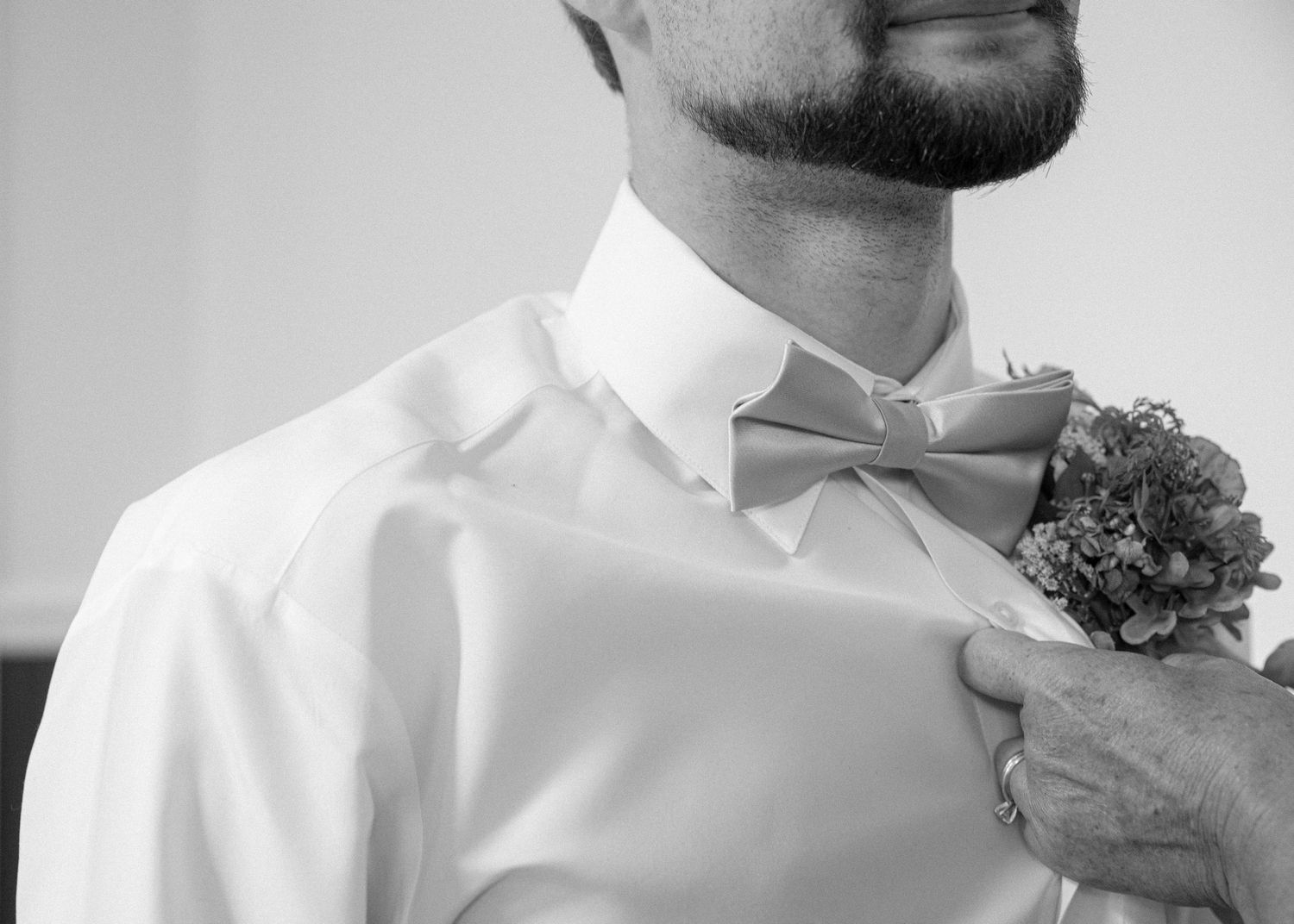 Close-up black and white shots of men in white dress shirts and boutonnières.