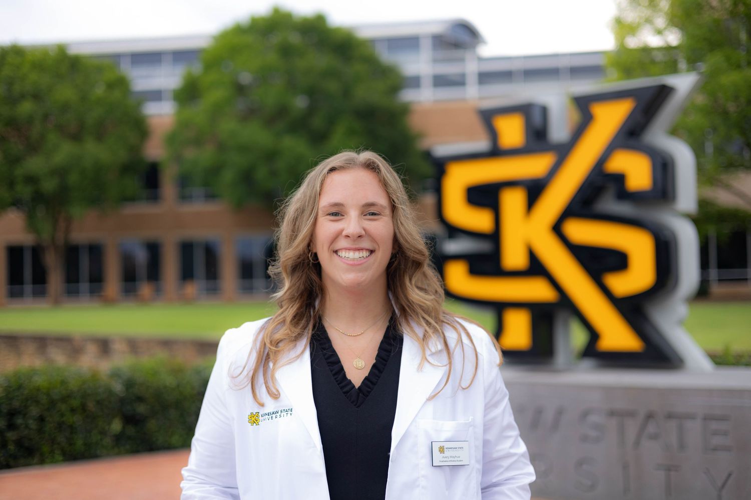 A series of outdoor shots of medical professionals in white coats and dark clothing on a campus with buildings and signage.