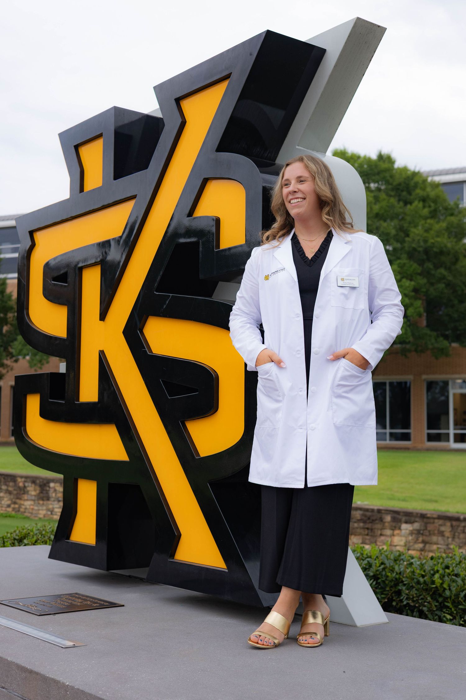 A series of professional headshots and portraits taken outdoors against a modern black and yellow architectural backdrop.