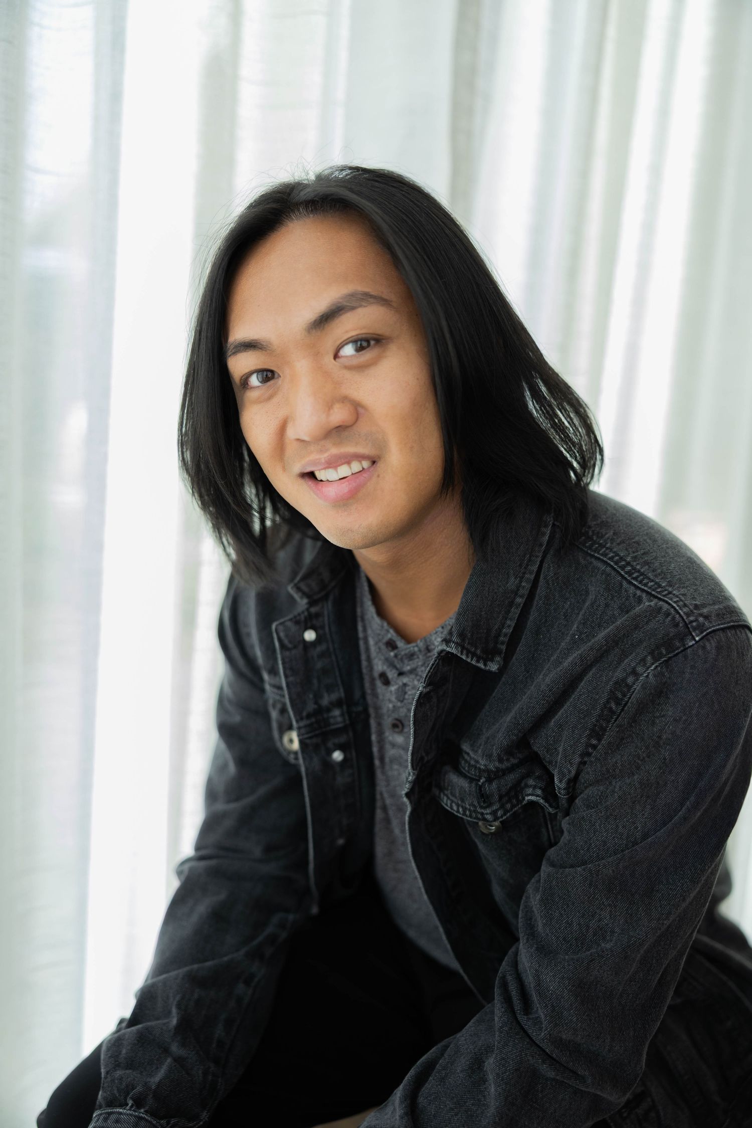 A sequence of black and white headshots showing someone smiling and posing against a white curtain background.