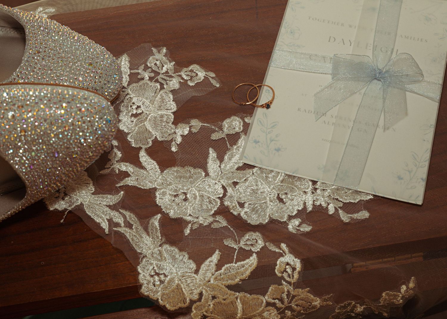 Delicate white lace trim pieces and decorative elements arranged on a dark wooden surface.
