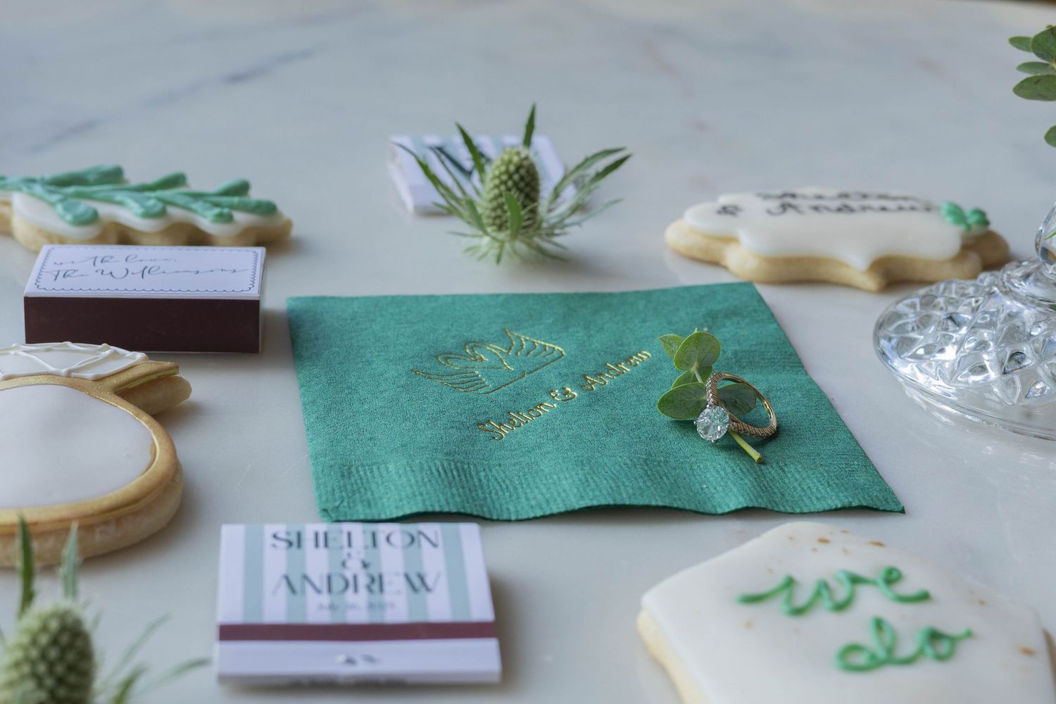 Hand-crafted appetizers and cocktails arranged on white marble counter with green decorative accents and napkins.