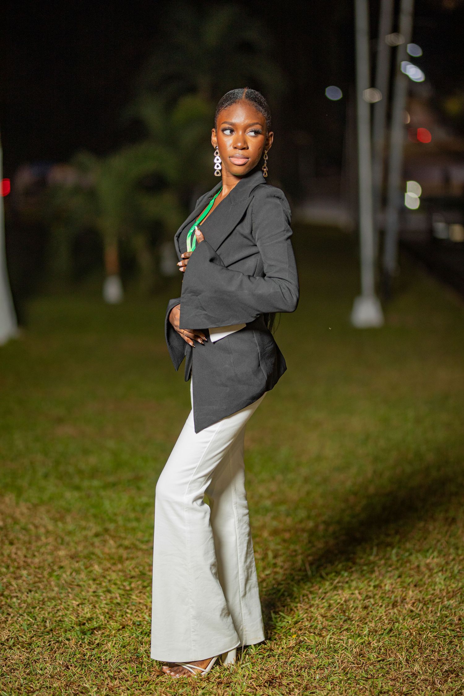 A person in a gray jacket and white skirt poses gracefully on grass in a series of dynamic outdoor shots.